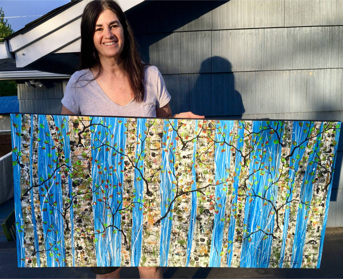 Debby Bloom holds one of her paintings that will be featured at Coppa in Juneau. Courtesy image.