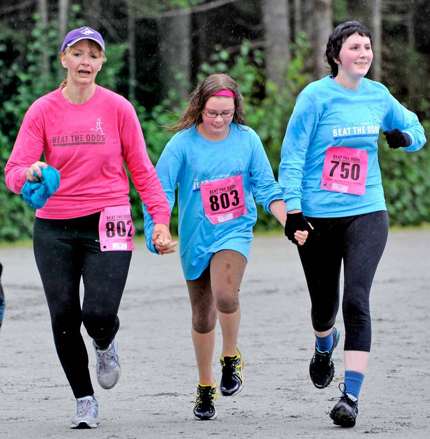 In this August 2012 photo, Cindy Stadt, left, finishes Saturday&rsquo;s Beat The Odds race with daughters Riley Stadt, center, and Lindsey Daniel, right. (Juneau Empire File)
