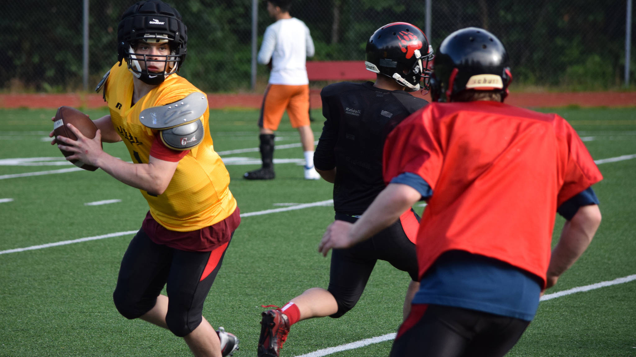 Quarterback Bubba Stults rolls out of the pocket during Juneau-Douglas High School football practice on Tuesday, July 1. (Nolin Ainsworth | Juneau Empire)