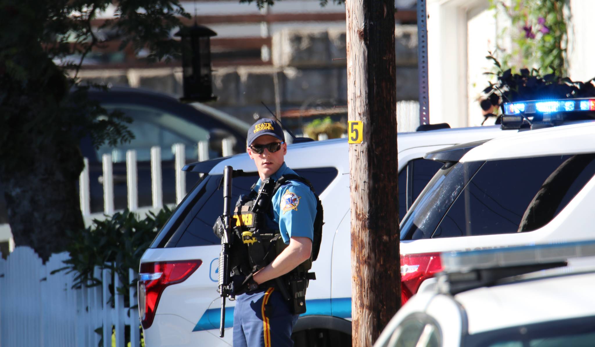 An Alaska State Trooper stands guard at the Fourth Street intersection to secure the perimeter while a search warrant is being served at 423 Fourth St. on Friday afternoon. (Photo courtesy of Matt Gruening)