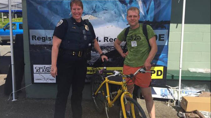 Juneau Police Department Lt. Kris Sell with a bicyclist during the registration drive at the Duck Derby on Aug. 5, 2017. (Courtesy Photo)