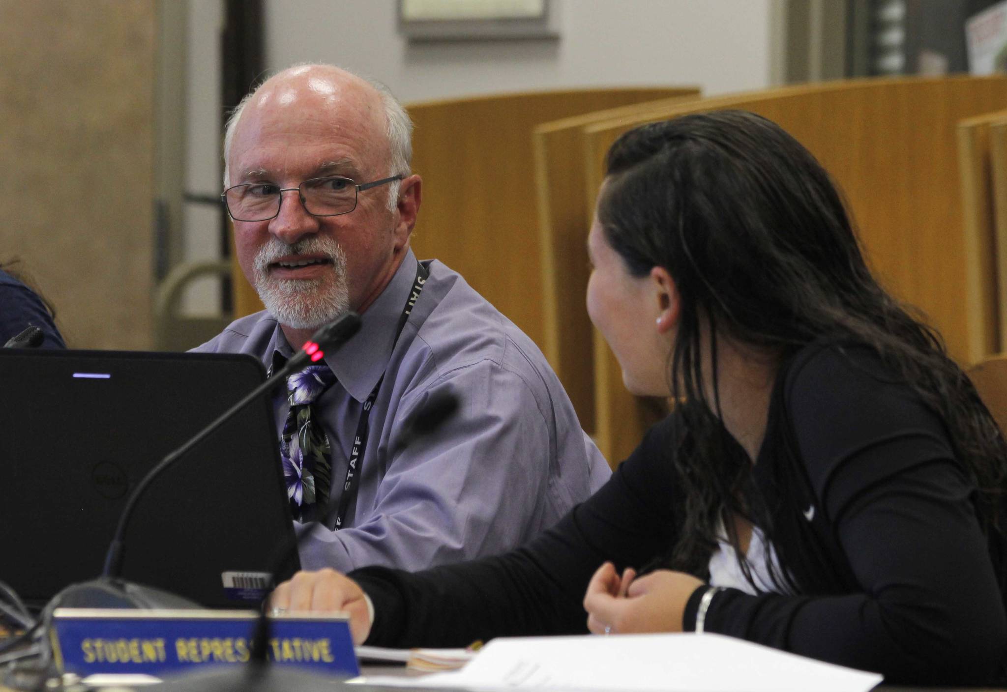 Juneau School District Superintendent Mark Miller smiles at Student Representative Dessa Gerger, a junior at Juneau-Douglas High School, at Tuesday’s Board of Education meeting. Topics at Tuesday’s meeting included teacher shortages and a new policy manual for the district. ALEX McCARTHY |  JUNEAU EMPIRE