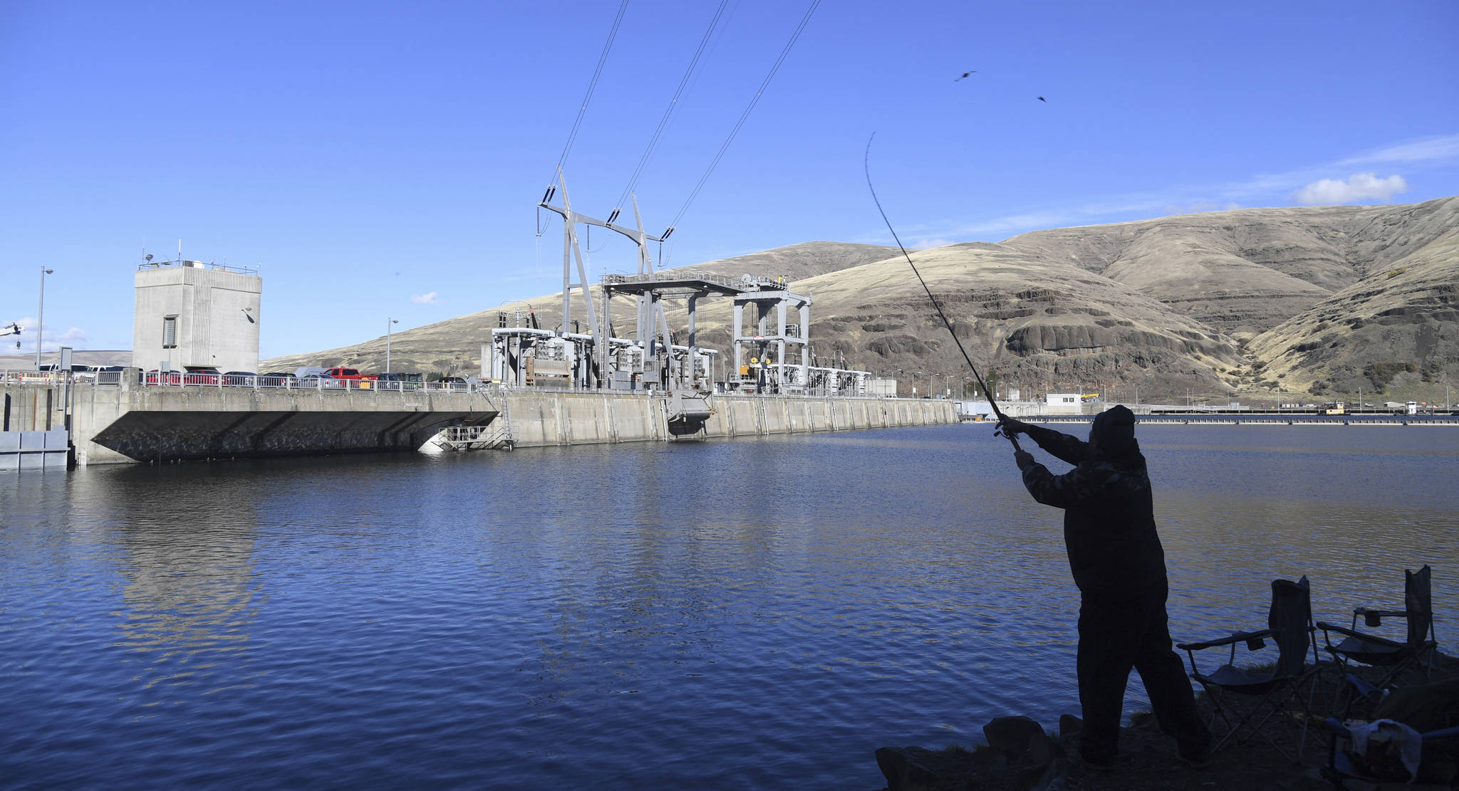 In this Oct. 19, 2016 photo, a man fishes for salmon in the Snake River above the Lower Granite Dam in Washington state. A group that represents farmers says saving imperiled salmon in the largest river system in the Northwest U.S. is too costly and is turning to the Trump administration. The Columbia-Snake River Irrigators Association wants the government to convene a Cabinet-level committee known as the “God Squad” due to its authority to allow exemptions to the Endangered Species Act. (Jesse Tinsley | The Spokesman-Review)