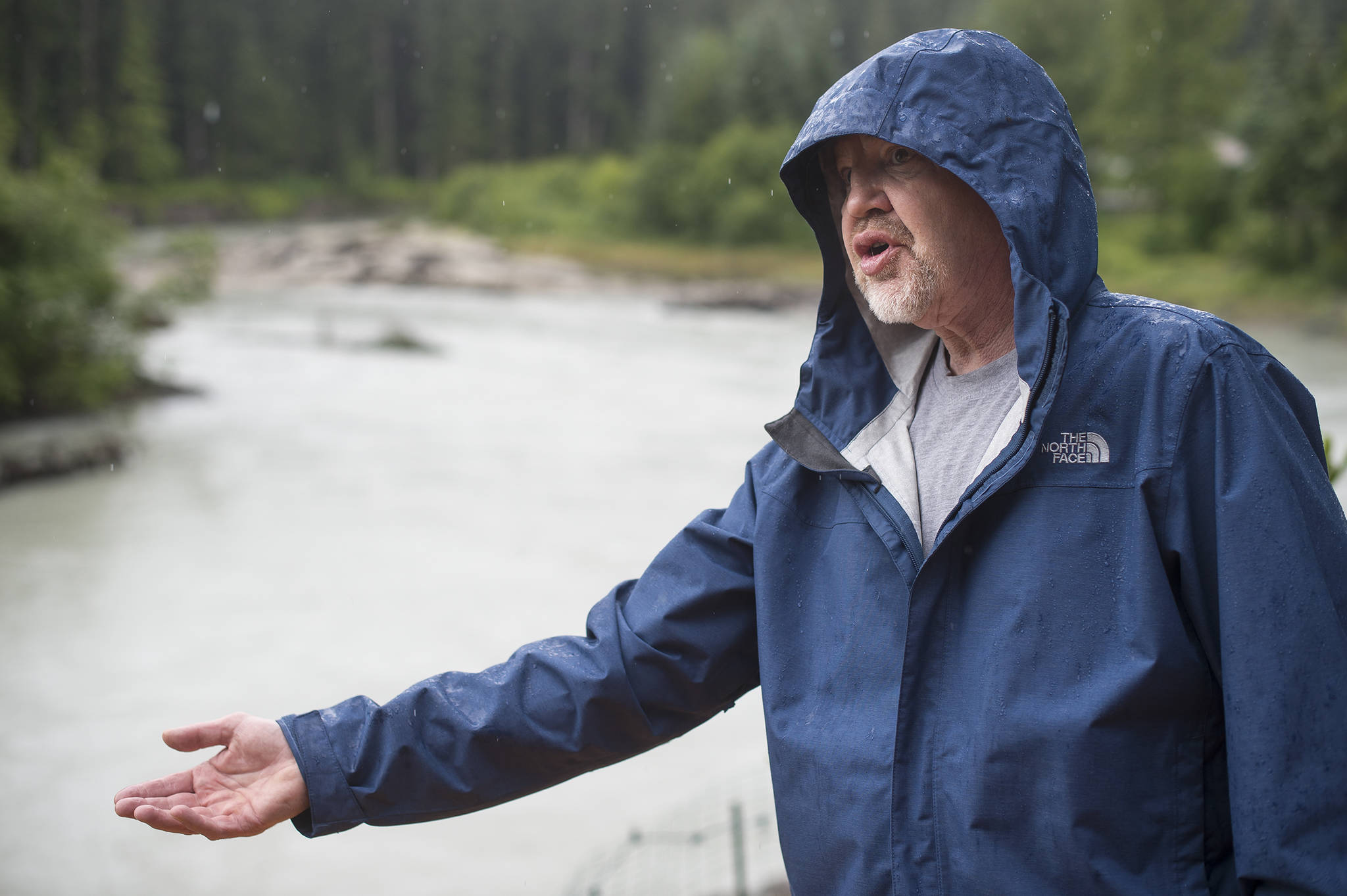 In this July 13 photo, Norman Staton talks about how the Mendenhall River is eroding his Meander Way property. Stanton is trying convince the city and his neighbors to pay to fortify the embankment. (Michael Penn | Juneau Empire File)