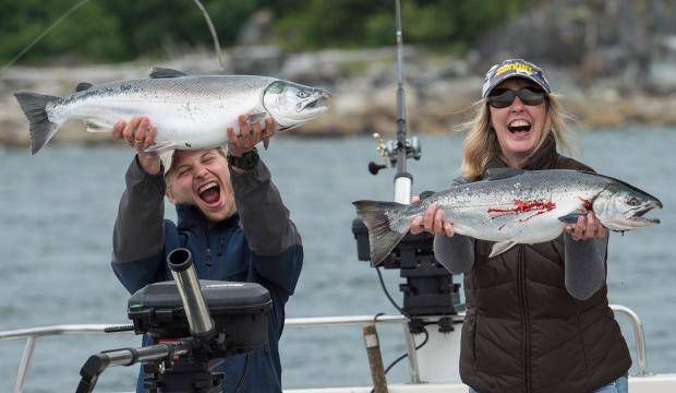 Trevin Carlile and Sharon Burns show their excitement about silver salmon caught during the 71st Annual Golden North Salmon Derby on Friday, Aug. 11, 2017. (Michael Penn | Juneau Empire)