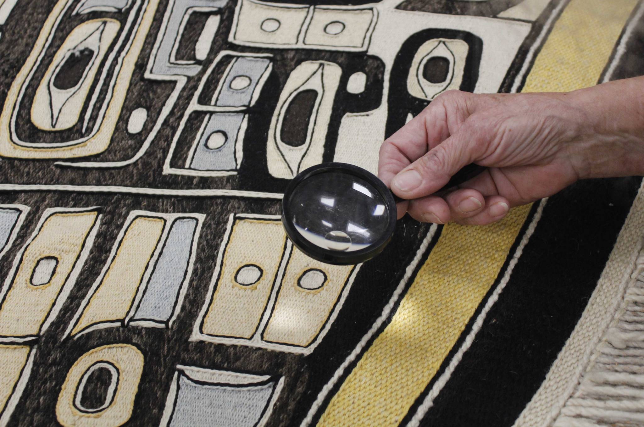 Weaver Kay Field Parker examines a Chilkat robe that was donated to Sealaska Heritage Institute this week. The robe is estimated to be from the late 1800s or late 1900s and is expected to be an important teaching tool for weavers. (Alex McCarthy | Juneau Empire)