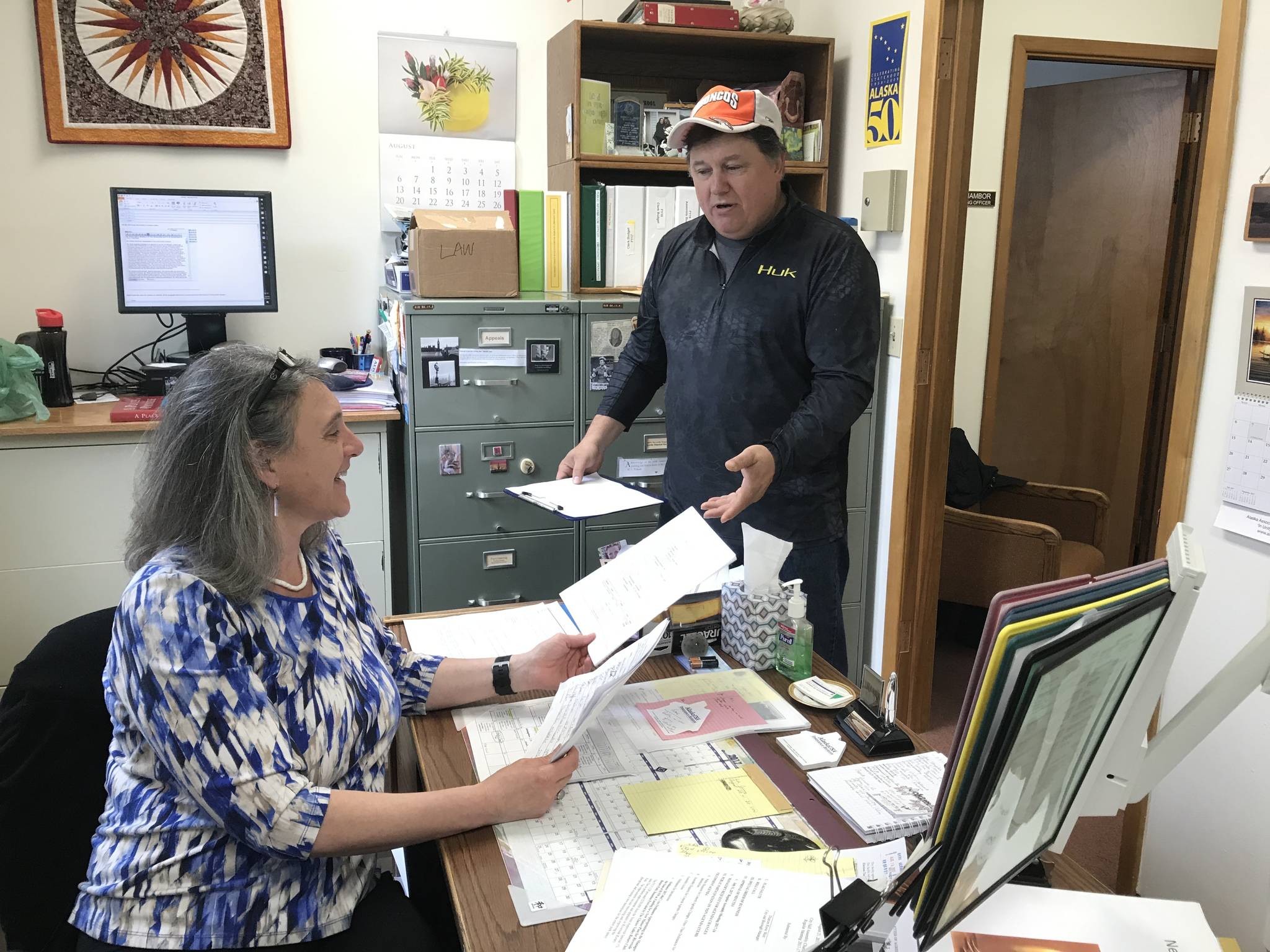 City and Borough of Juneau Assembly candidate Chuck Collins turns in his paperwork to City Clerk Laurie Sica on Monday. Collins said the people of Juneau “need to take control of our town again.” (Alex McCarthy | Juneau Empire)