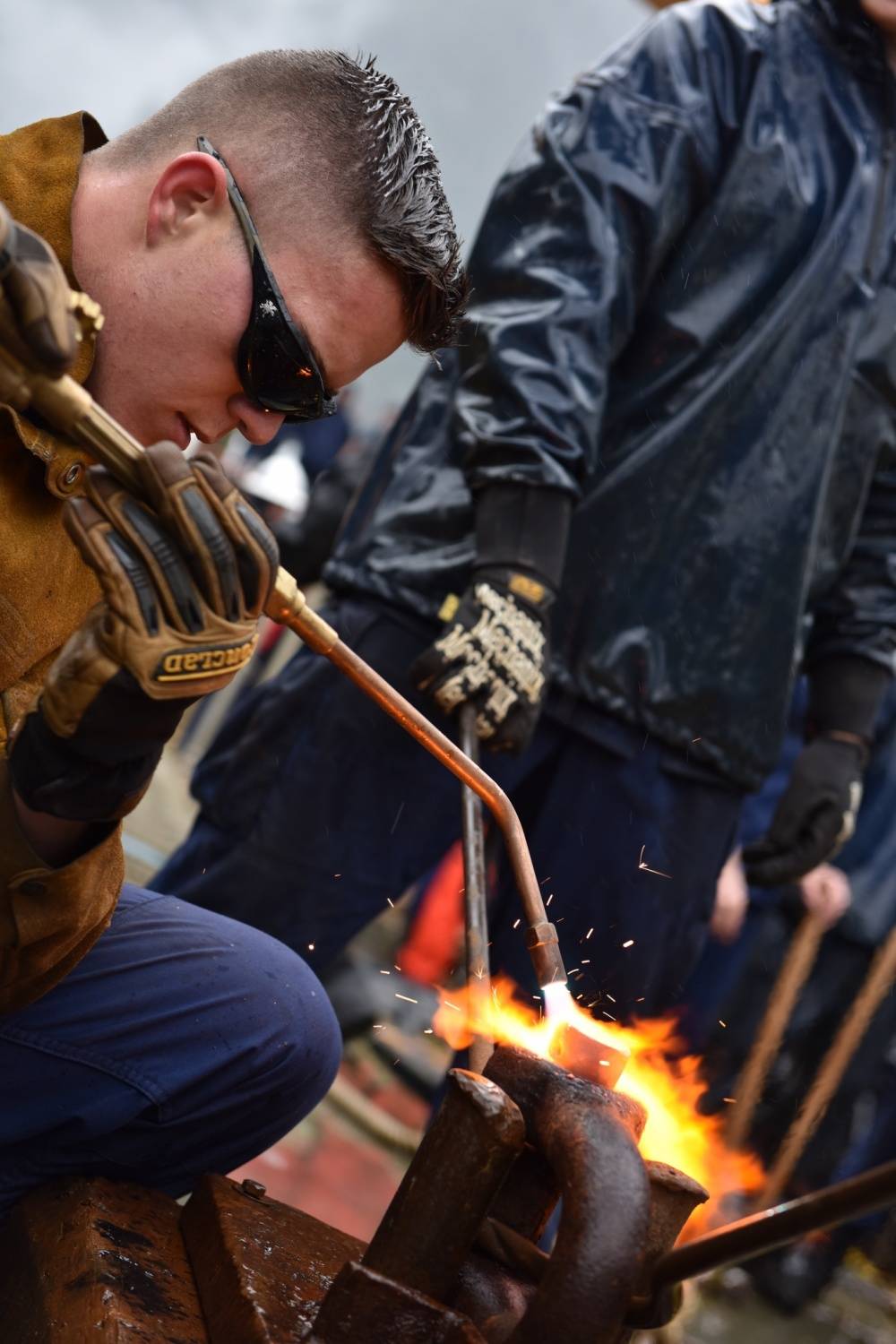 A Coast Guard Cutter Sycamore crewmember heats a rivet pin during the heat-and-beat competition, where teams use torches and hammers to seal shackles for time, during the Buoy Tender Roundup Olympics at Coast Guard Station Juneau on Wednesday, Aug. 16, 2017. This year’s roundup included eight U.S. Coast Guard and Canadian buoy tenders, stationed throughout Alaska and the Pacific Northwest. (Petty Officer 1st Class Jon-Paul Rios | U.S. Coast Guard)