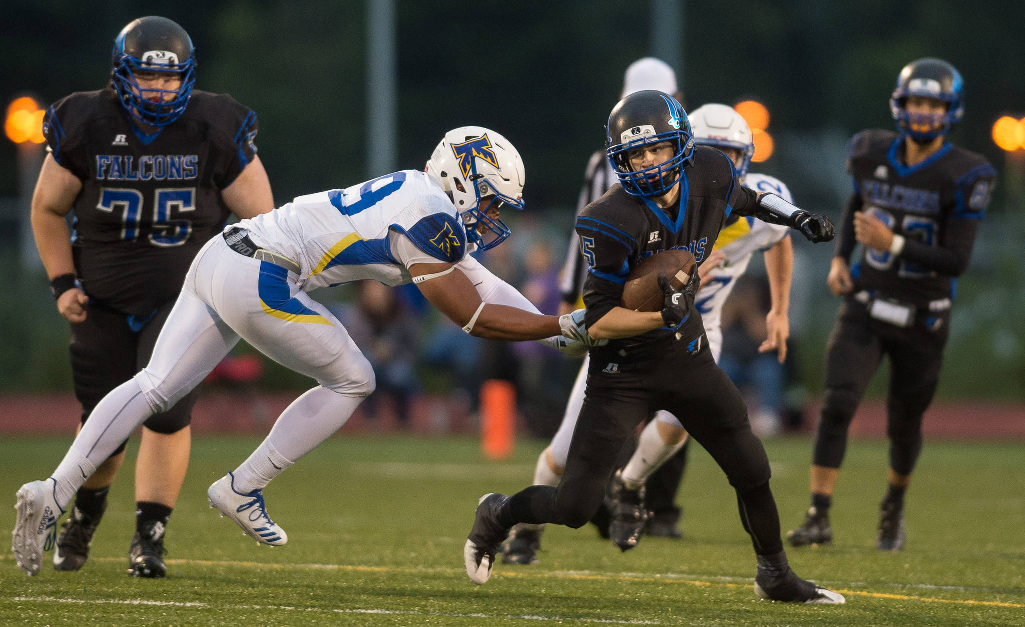 Thunder Mountain’s Hansel Hinckle is chased by Kodiak’s Jherome LaDera at TMHS on Friday, Aug. 18, 2017. TMHS won 14-7. (Michael Penn | Juneau Empire)