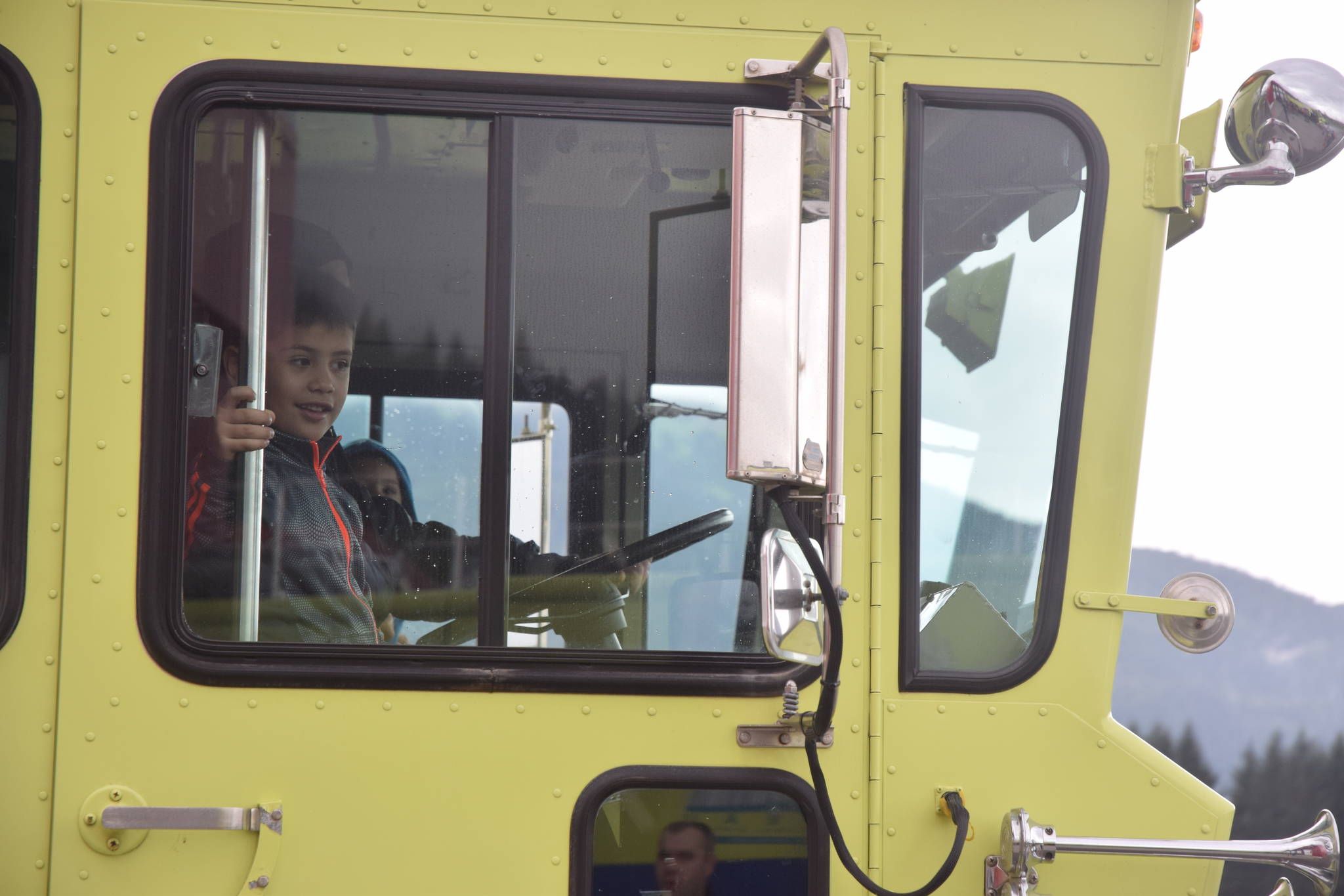 A youngster takes a ride in Capital City Fire/Rescue’s Aircraft Response Firefighting vehicle on Saturday. (Kevin Gullufsen | Juneau Empire)