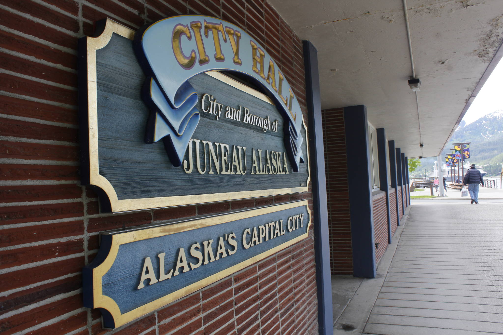 A pedestrian walks by City Hall on June 7, 2017. Elections for the City and Borough of Juneau are Oct. 3, and there are two initiatives on the ballot. (Alex McCarthy | Juneau Empire)