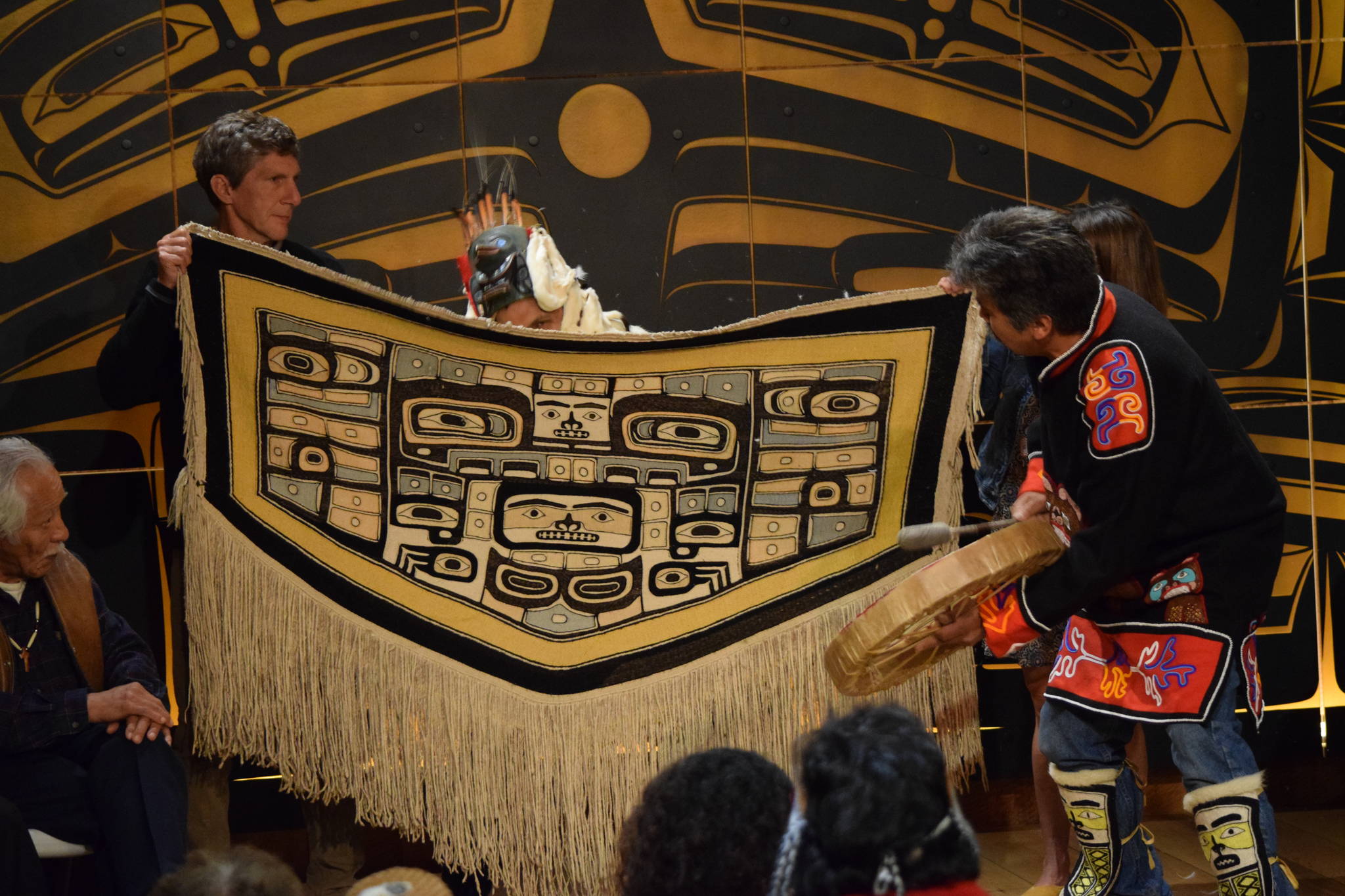 Joe Zuboff, right, beats a drum during a ceremony celebrating the return of a Chilkat robe to the Sealaska Heritage Institute. (Kevin Gullufsen | Juneau Empire)