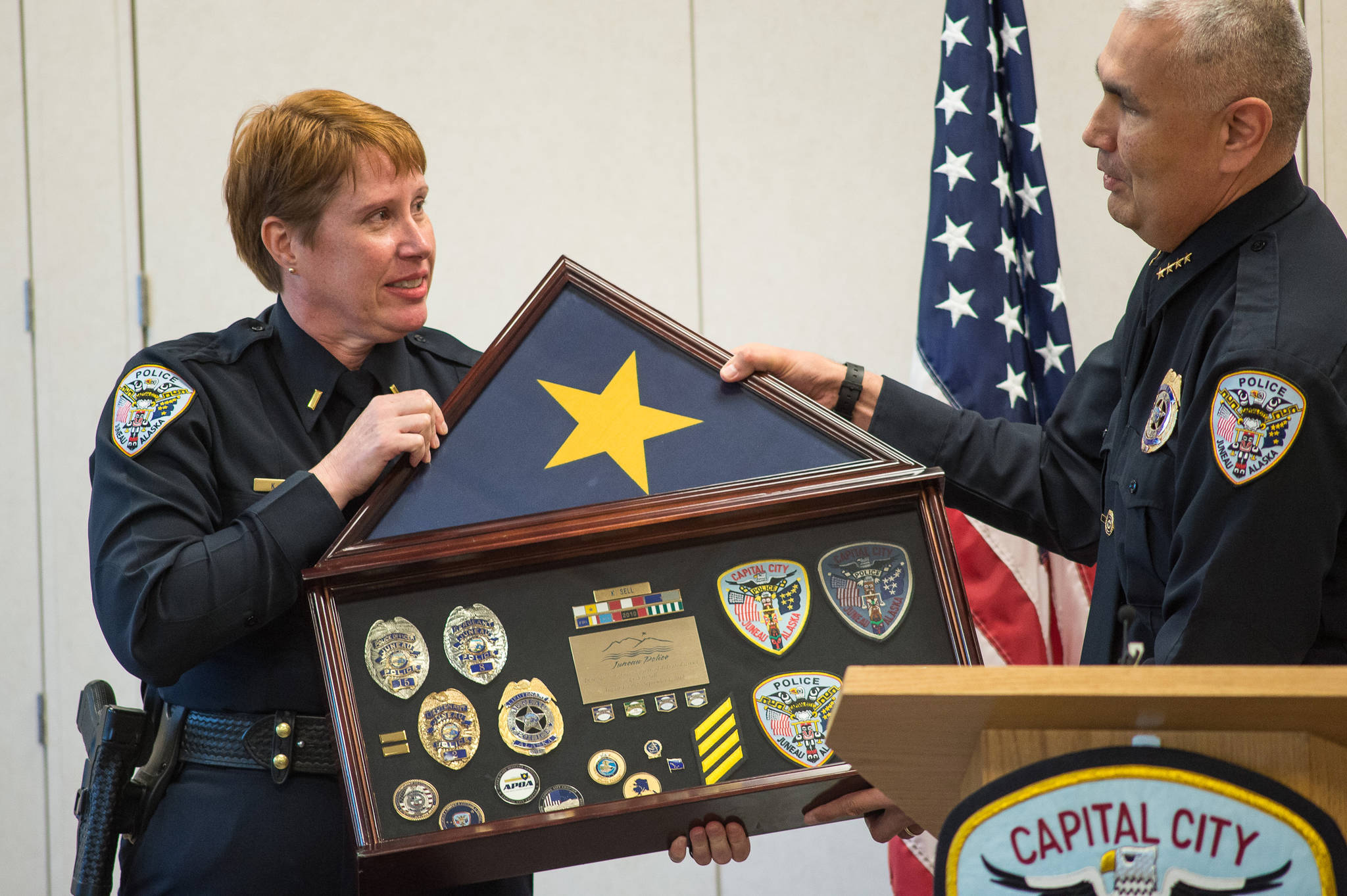 Lt. Kris Sell receives a framed case of her badges and awards from Police Chief Ed Mercer at her retirement party at the Juneau Police Department on Thursday, Aug. 31, 2017. Sell started as a patrol officer in 1997.