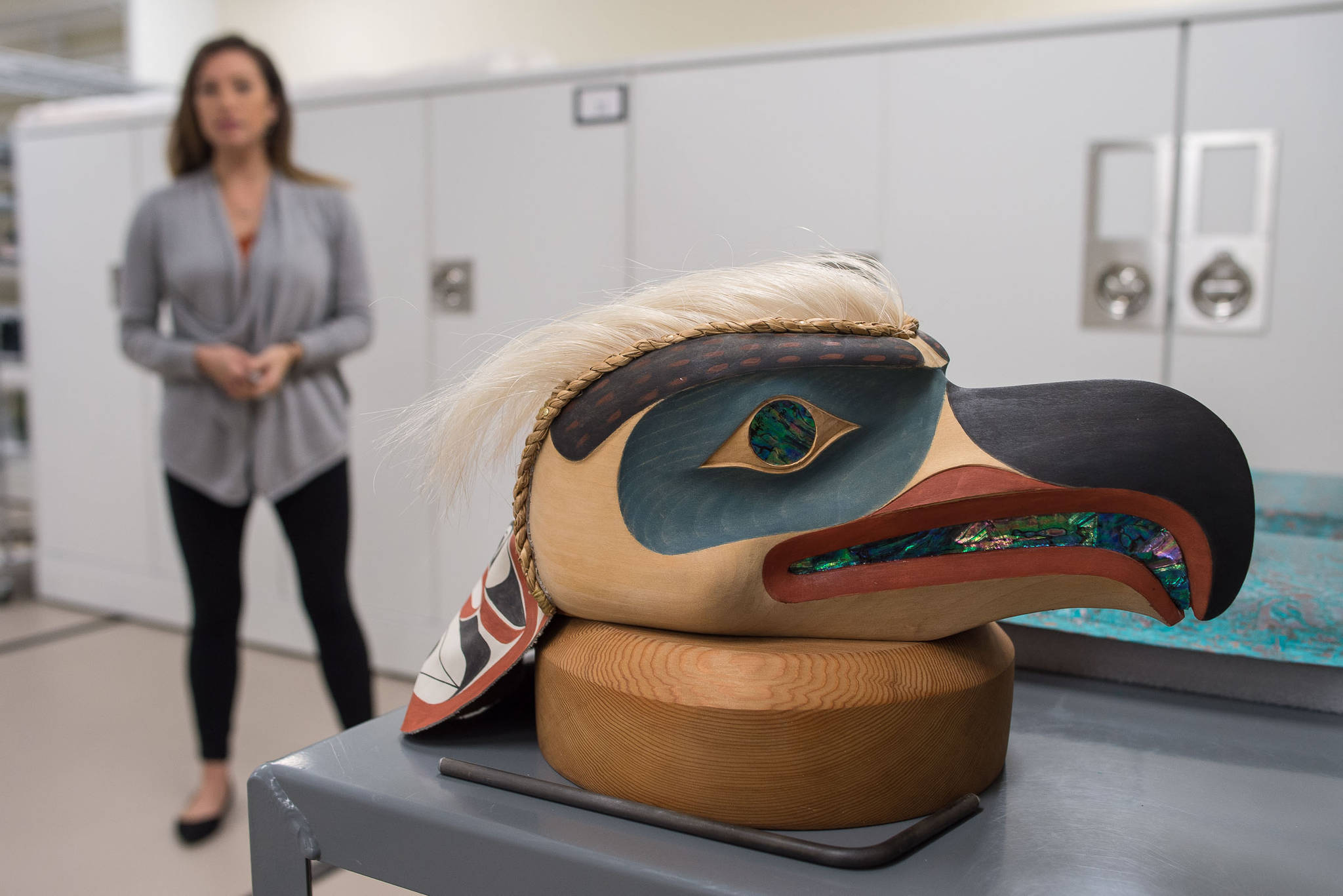 Coordinator Carmaleeda Estrada stands next to an eagle headdress by artist Duane Pasco at the Walter Soboleff Center on Wednesday, Sept. 27, 2017. The artwork is one of more than 50 pieces featured in Sealaska Heritage Institute&rsquo;s second Tin&