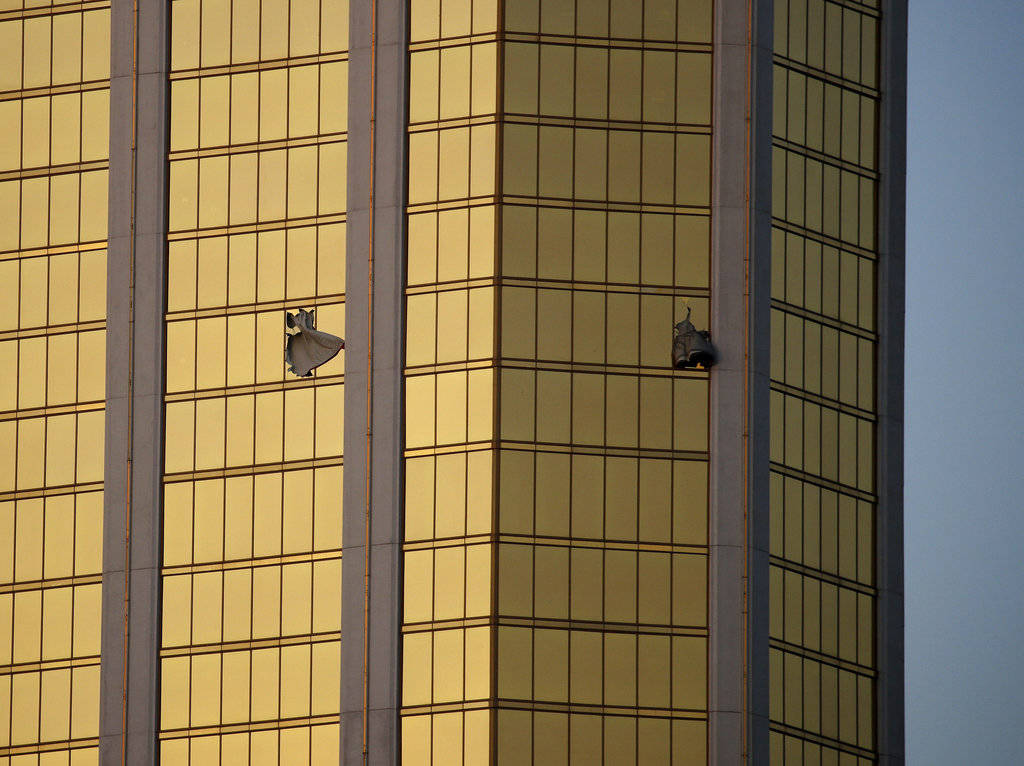 In this Monday, Oct. 2, 2017 photo, drapes billow out of broken windows at the Mandalay Bay resort and casino on the Las Vegas Strip, following a mass shooting at a music festival in Las Vegas. From two broken-out windows of the resort, Stephen Craig Paddock had an unobstructed view to rain automatic gunfire on the crowd, with few places for them to hide. Sunday night’s bloodbath left dozens of people dead and hundreds wounded. (John Locher | The Associated Press)