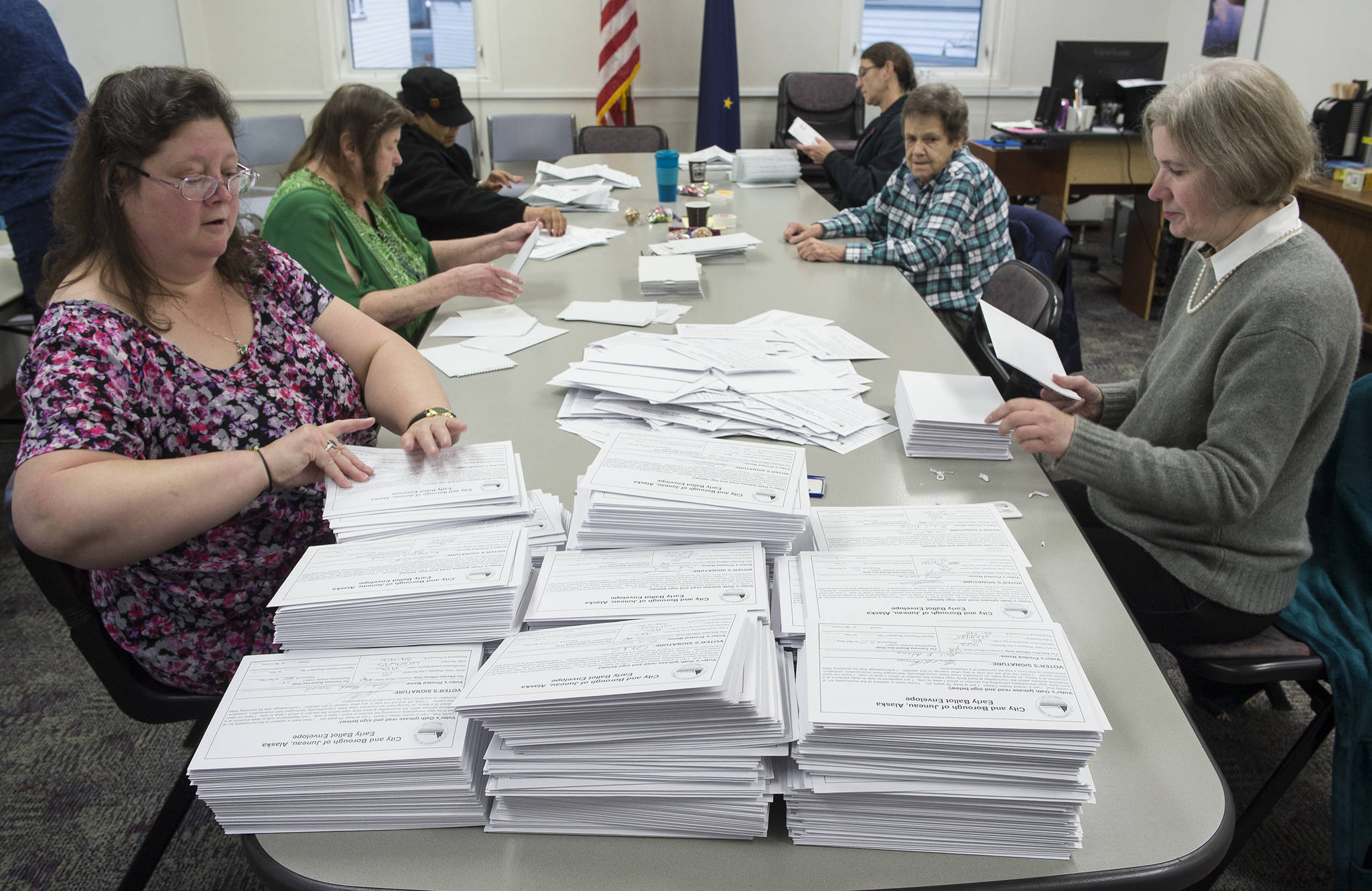 Members of the Absentee Questioned Ballot Review Board open ballots before counting at the City Hall on Friday, Oct. 6, 2017. (Michael Penn | Juneau Empire)