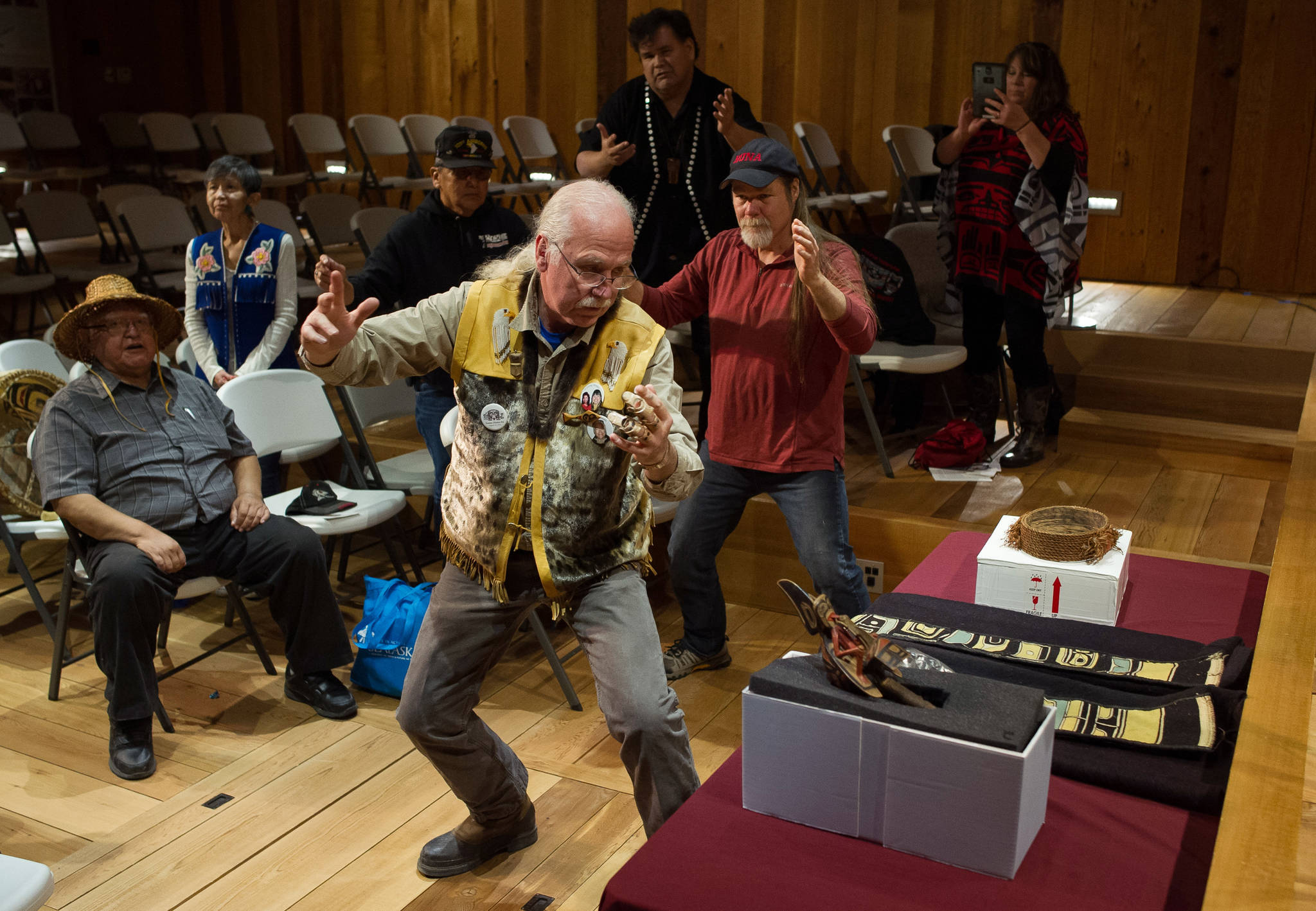 Gordon Greenwald, center, Fred Fulmer, right, and Alfie Price dance in honor of three items being transferred from the University of Pennsylvania back to a Hoonah clan during a repatriation ceremony at the Walter Soboleff Center on Wednesday, Oct. 11, 2017. (Michael Penn | Juneau Empire)