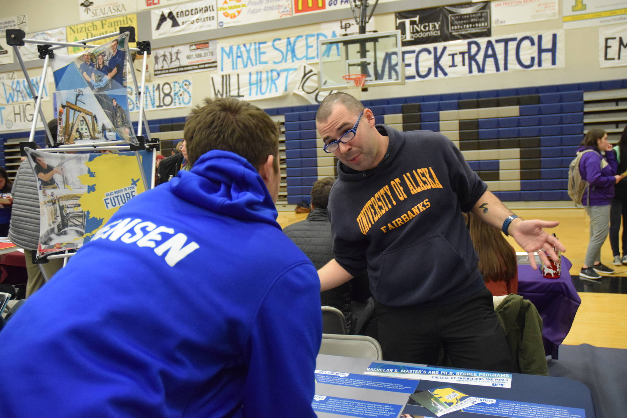 Kevin Gullufsen | Juneau Empire TMHS sophomore Cole Jensen talks with a representative from the University of Alaska Fairbanks’ engineering program on Friday’s college and career fair at TMHS.