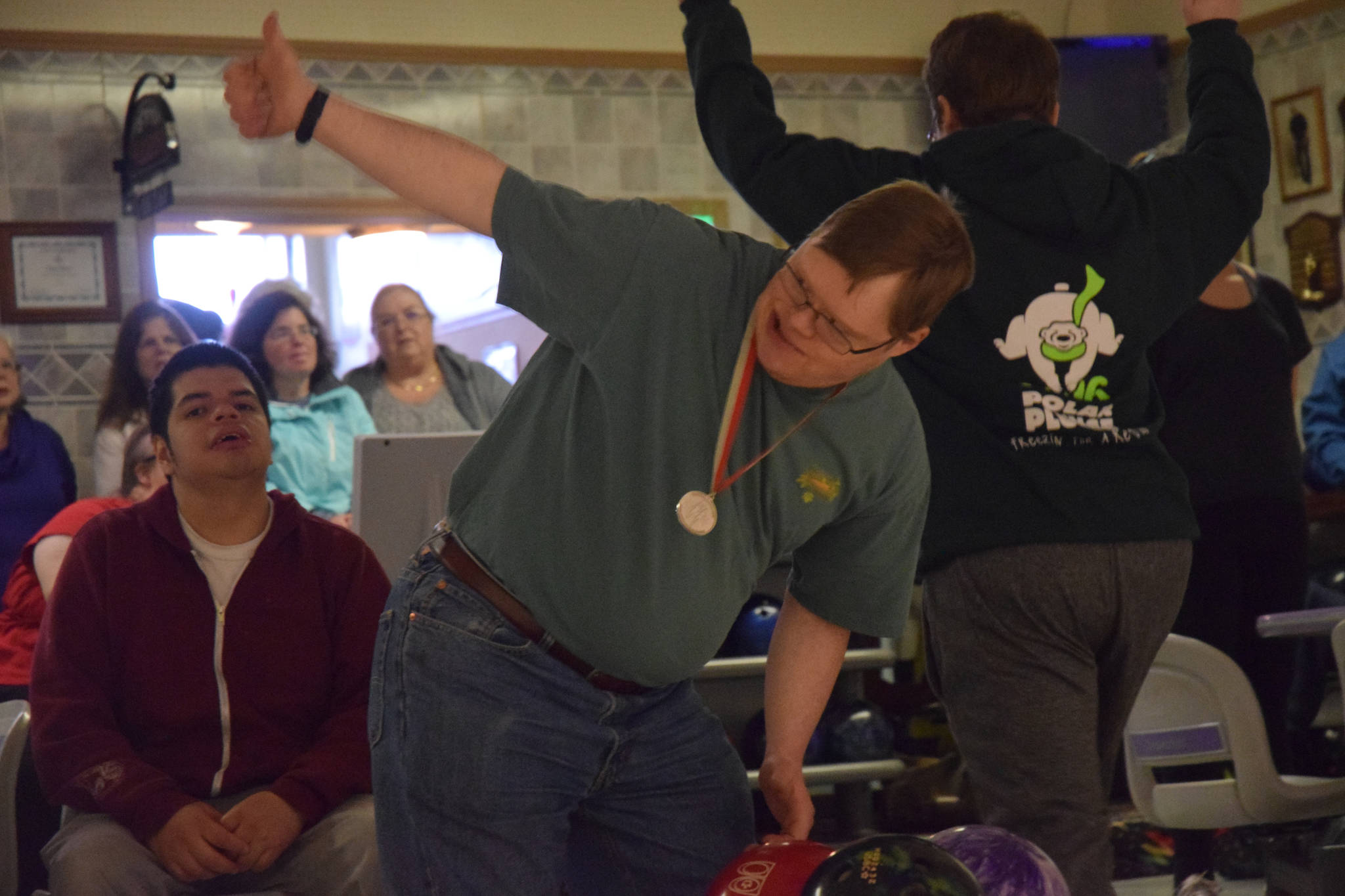 Athlete Carl Cogland Behnert gives a thumbs up to his Special Olympics teammates at Taku Lanes on Sunday, Oct. 15. (Kevin Gullufsen | Juneau Empire)