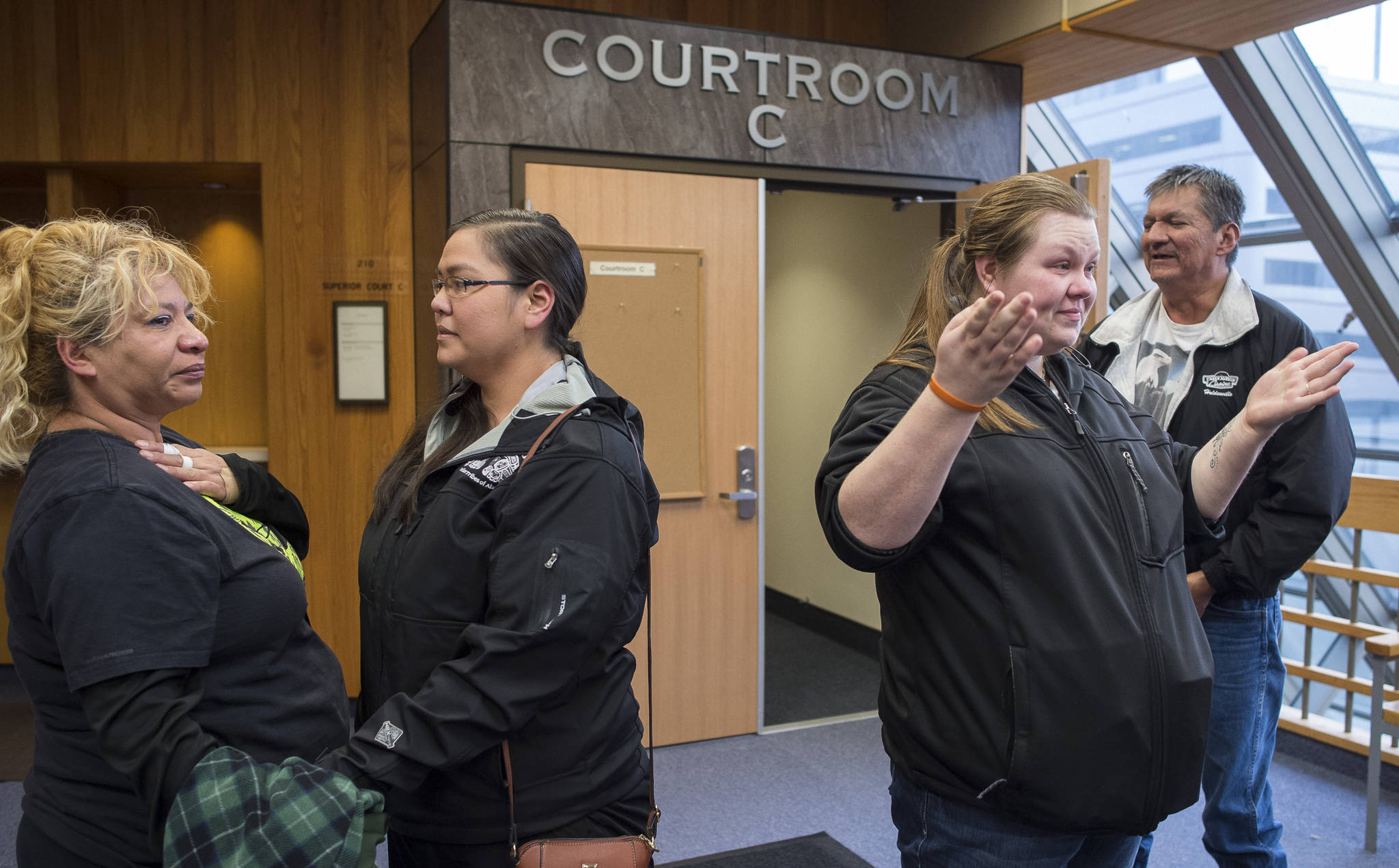Amanda Cook, left, and her husband, Don, right, react with Tiffany Johnson, second from right, and Samantha Sharclane to the guilt verdicts of Christopher Strawn in Juneau Superior Court on Wednesday, Oct. 18, 2017, on charges of first-degree and second-degree murder, manslaughter, criminally negligent homicide and third-degree assault in the shooting death of Brandon Cook nearly two years ago.