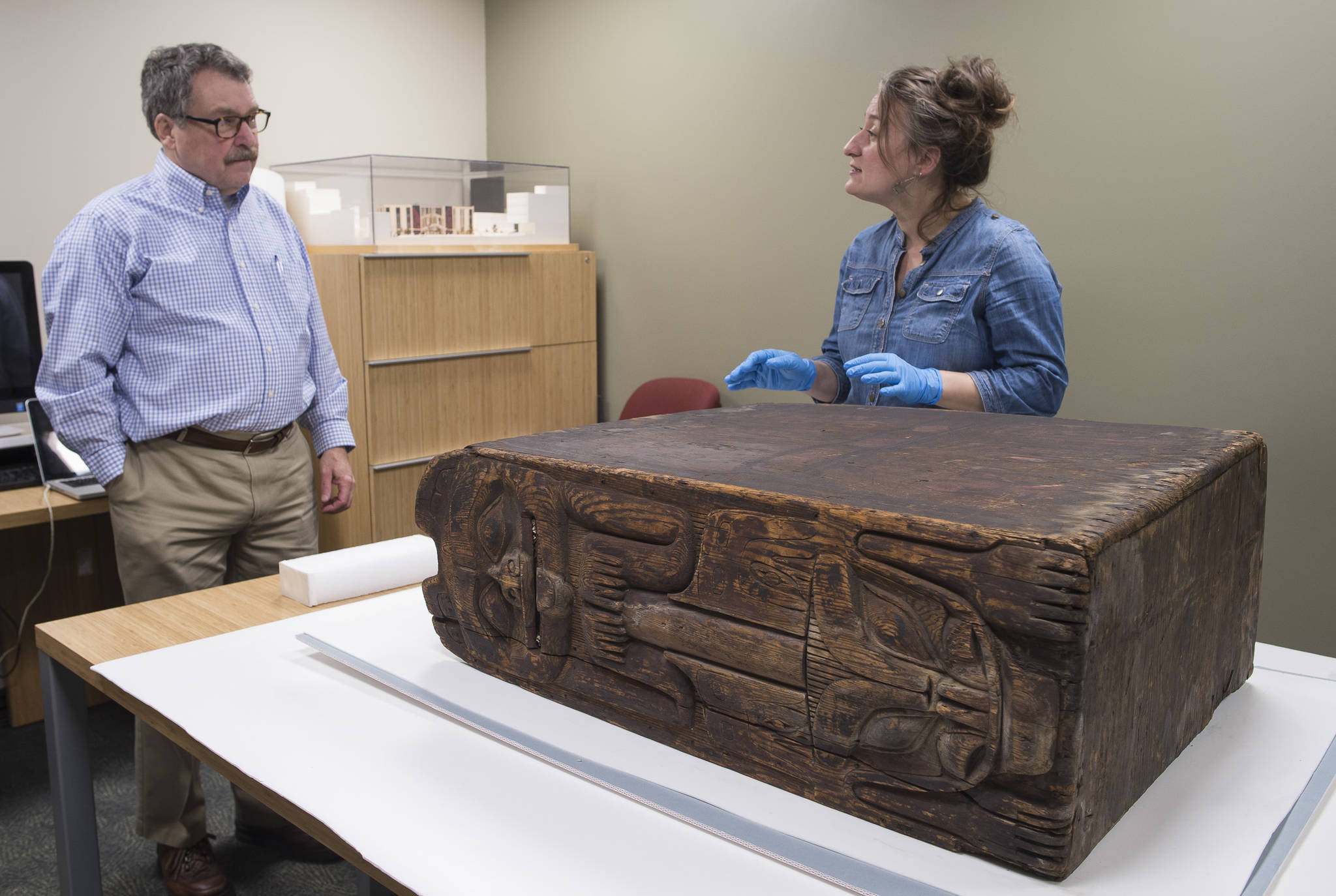 Chuck Smythe, Ph.D. History and Culture Director for Sealaska Heritage Institute, and Nicole Peters, an arts conservator from Skagway, talk about a wooden box drum that is currently undergoing restoration at SHI on Wednesday, Oct. 18, 2017. (Michael Penn | Capital City Weekly)