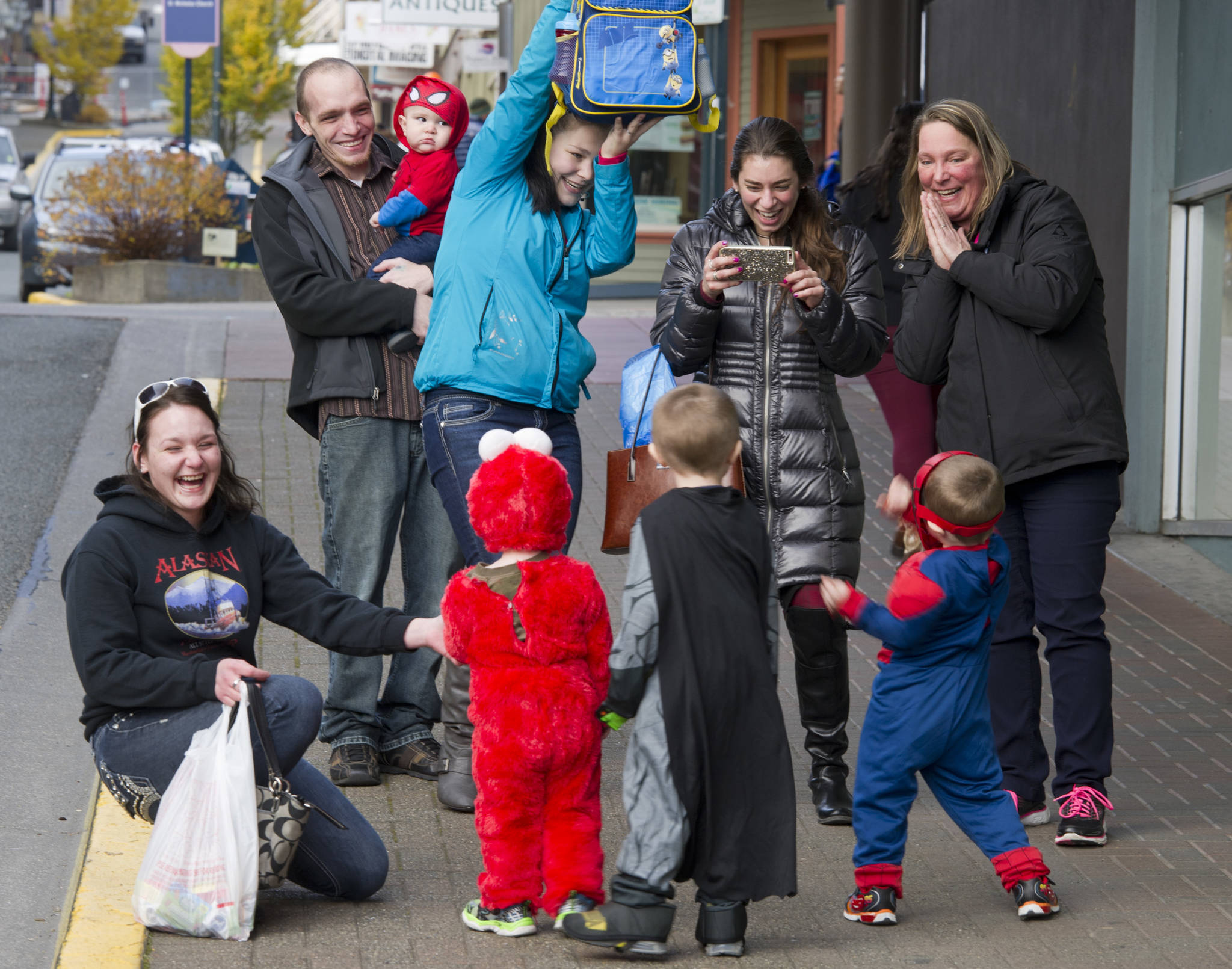 Parents, grandparents and friends have fun photographing their young ones on Seward Street for Halloween 2016. More than 50 businesses downtown welcomed trick-or-treaters last year. (Michael Penn | Juneau Empire)