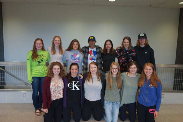 Juneau Teens for Change pose inside Thunder Mountain High School. Back row, left to right: Audrey Welling, Mary Landes, Erin Wallace, Miguel Cordero, Summer Smith, Azure Briggs, and Ezra Geselle. Front row, left to right: Bridget Gehring, Anna Rivest, Kayla Simpson, Mikayla May, Core Gehring, and Sally Thompson. (Clara Miller | Capital City Weekly)