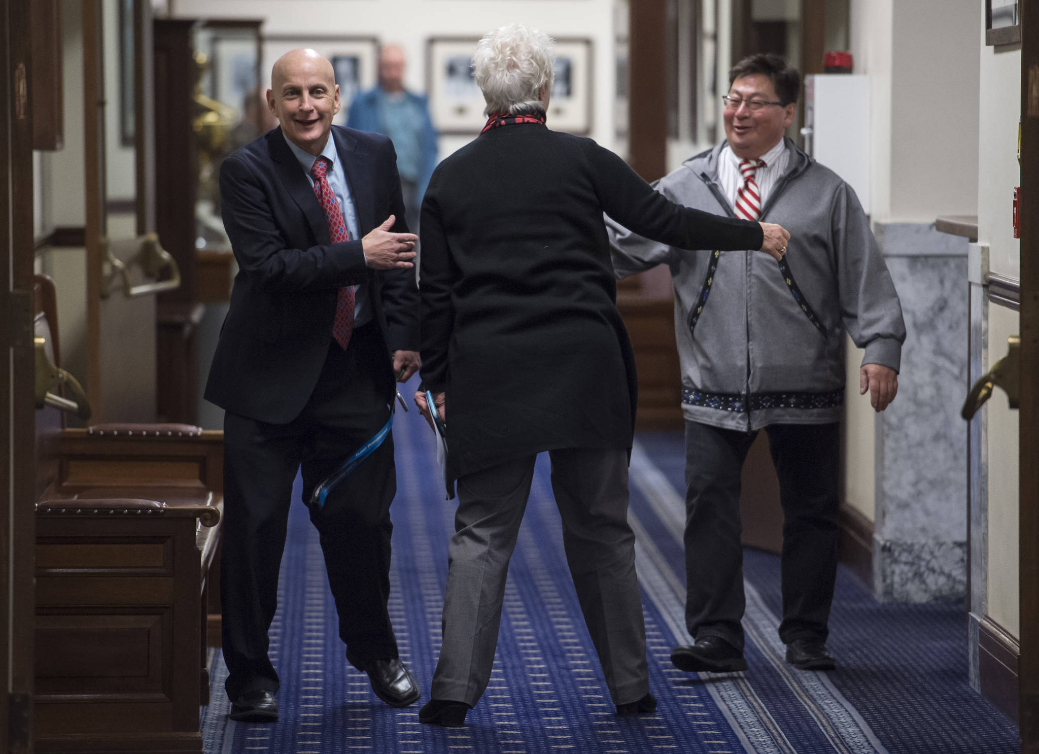 Rep. Daniel Ortiz, NA-Ketchikan, left, Rep. Louise Stutes, R-Kodiak, center, and Rep. Dean Westlake, D-Kotzebue, greet each other on the first day of the fourth Special Session of the 30th Alaska Legisture on Monday, Oct. 23, 2017.