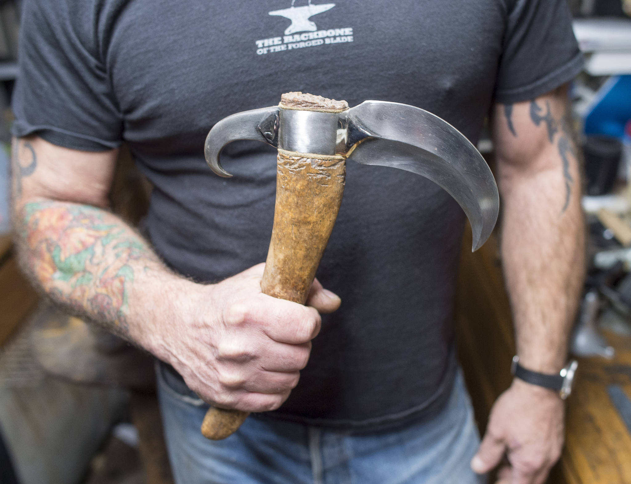 Bladesmith David Mirabile shows an axe he made from Damascus steel and a walrus oosik in his Juneau shop on Thursday, Oct. 26, 2017. (Michael Penn | Juneau Empire)