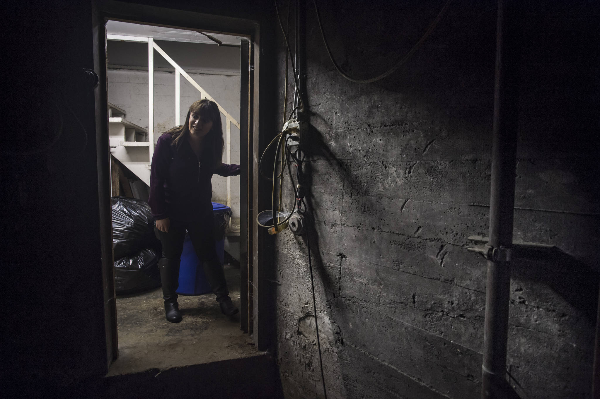 Juneau Drug manager Brenda Lamas peers into a basement storage room below the store on Monday, Oct. 30, 2017. The room is said to be haunted and Lamas said she will not enter the room. (Michael Penn | Juneau Empire)