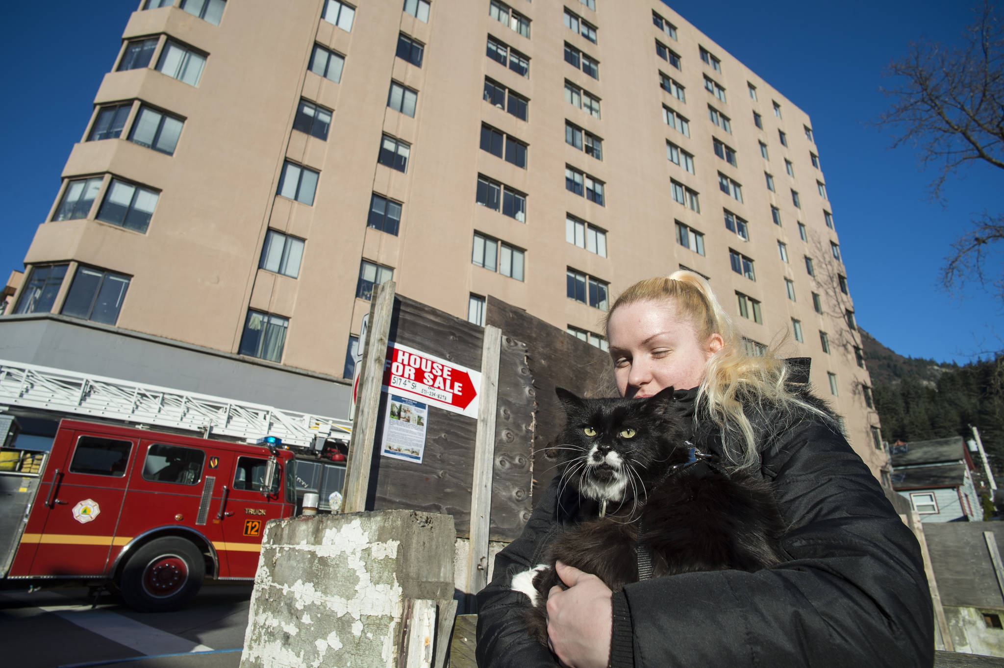 Cassidy Coulter waits outside the Mendenhall Tower Apartments during a fire alarm on Wednesday, Nov. 8, 2017. Work on the building&rsquo;s boilers set off the alarm. (Michael Penn | Juneau Empire)