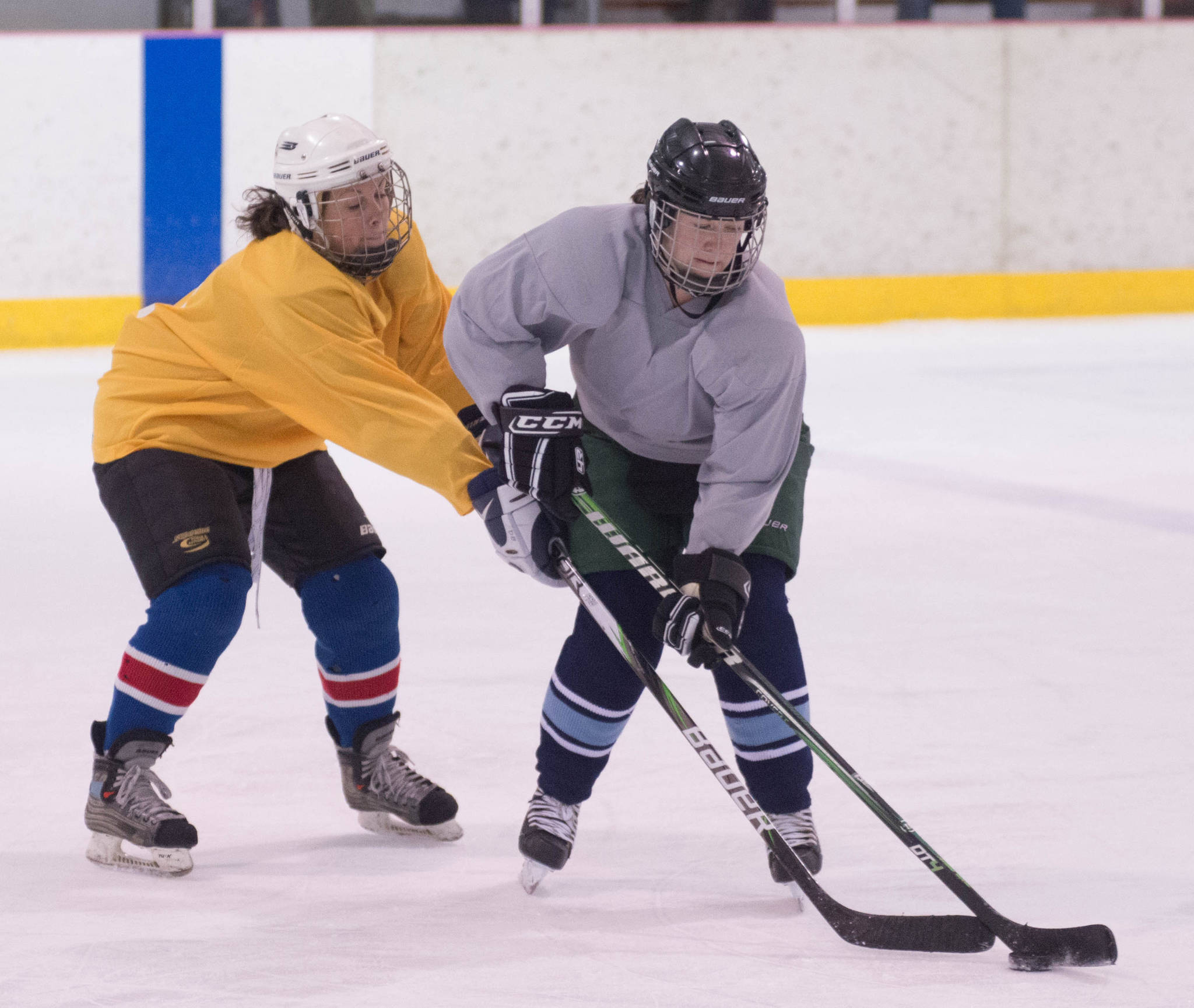 Dawn Welton (yellow) sneaks in front of Mo Miller to regain control of the puck during last year’s Juneau Jamboree at Treadwell Ice Arena. (Photo courtesy of Steve Quinn)