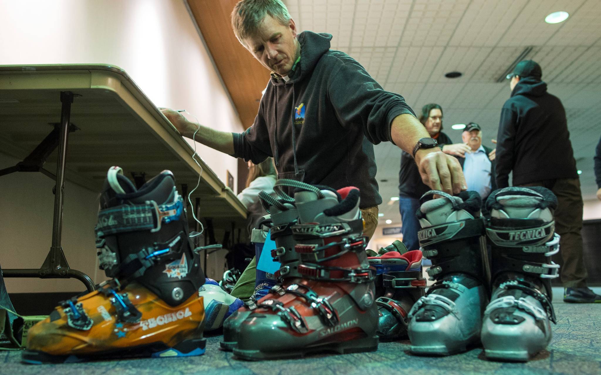 A volunteer handles ski boots to be sold at the Juneau Ski Sale on Saturday. (Michael Penn | Juneau Empire)