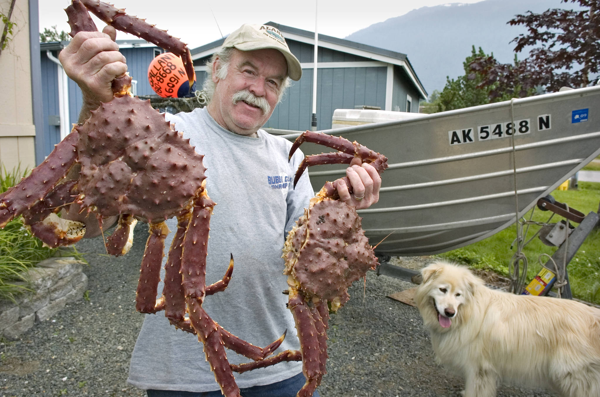Greg Gallant and his fishing partner, Kodi, show off their king crab catch in August 2009. (Michael Penn | Juneau Empire File)
