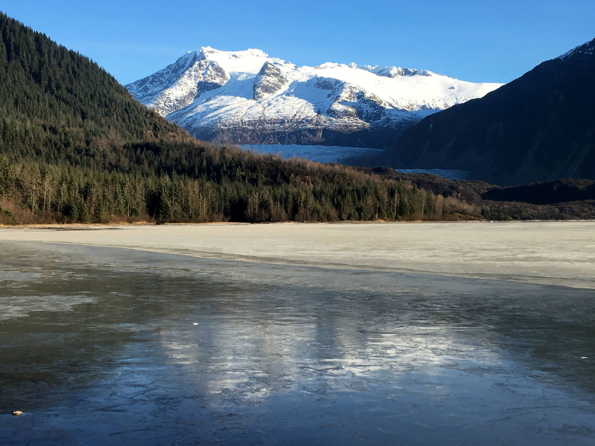 Mendenhall Glacier reflects in the thin ice of Mendenhall Lake. (Photo by Denise Carroll)