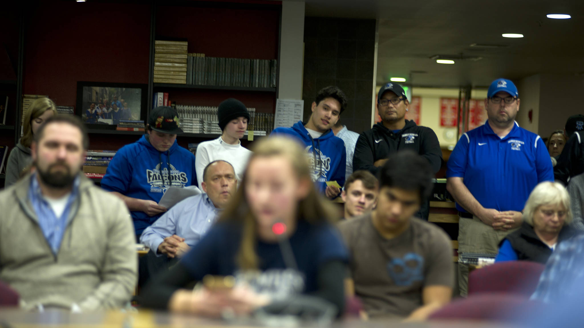 Thunder Mountain High School football coaching staff and players wait for their turn to give public testimony surrounding the consolidation of Juneau’s football teams under Juneau-Douglas High School, Wednesday, Nov. 14, 2017, in the JDHS Library. Coaches, players and TMHS student government members spoke in favor of establishing a program under a new name and colors. (Nolin Ainsworth | Juneau Empire)