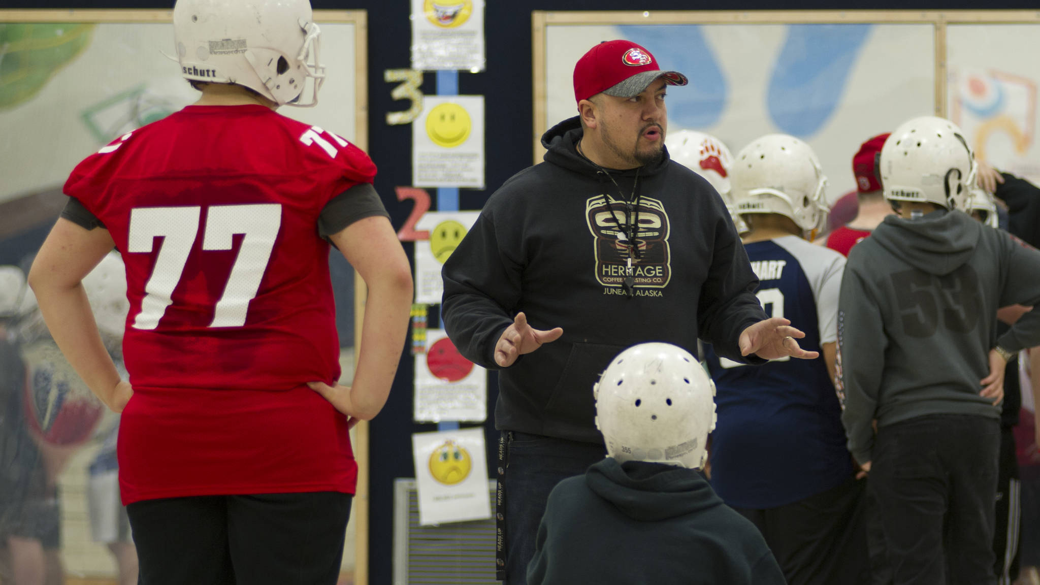 Juneau Youth Football League coach Marcos Morehouse instructs several 49ers players at a weeknight practice at Glacier Valley Elementary School, Wednesday, Nov. 15, 2017. The youth football team travels this week to Las Vegas, Nevada, for the National Youth Football Championships where they will play two games. (Nolin Ainsworth | Juneau Empire)