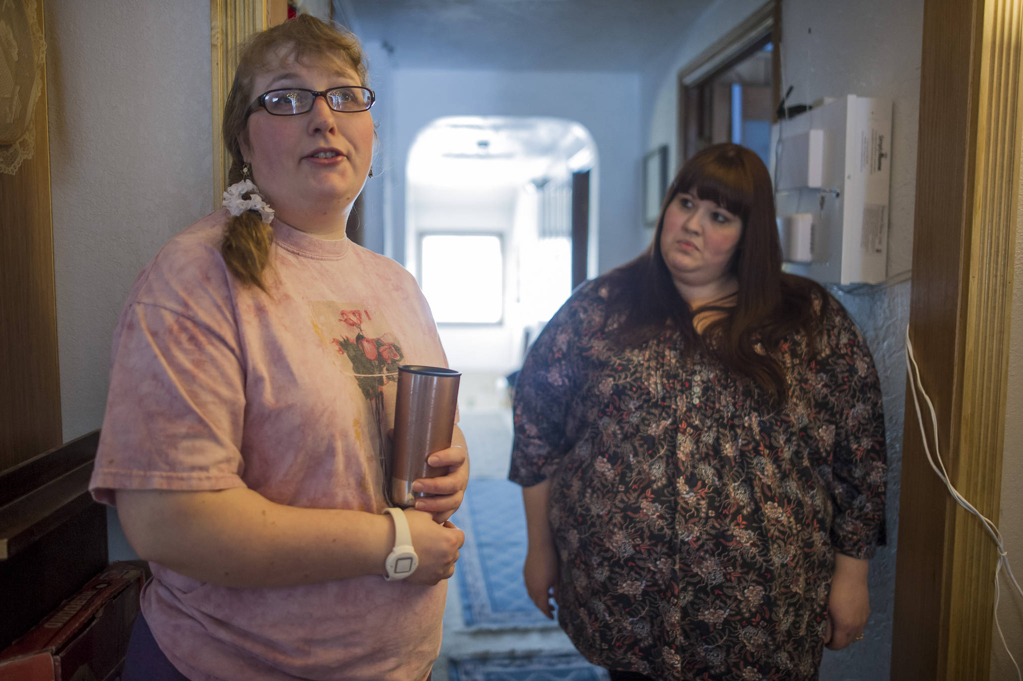Gina Frickey, left, and Sabrina Cardinal, a service coordinator for REACH, talk about new assistive technology being used in Frickey’s home to help her stay safe. (Michael Penn | Juneau Empire)