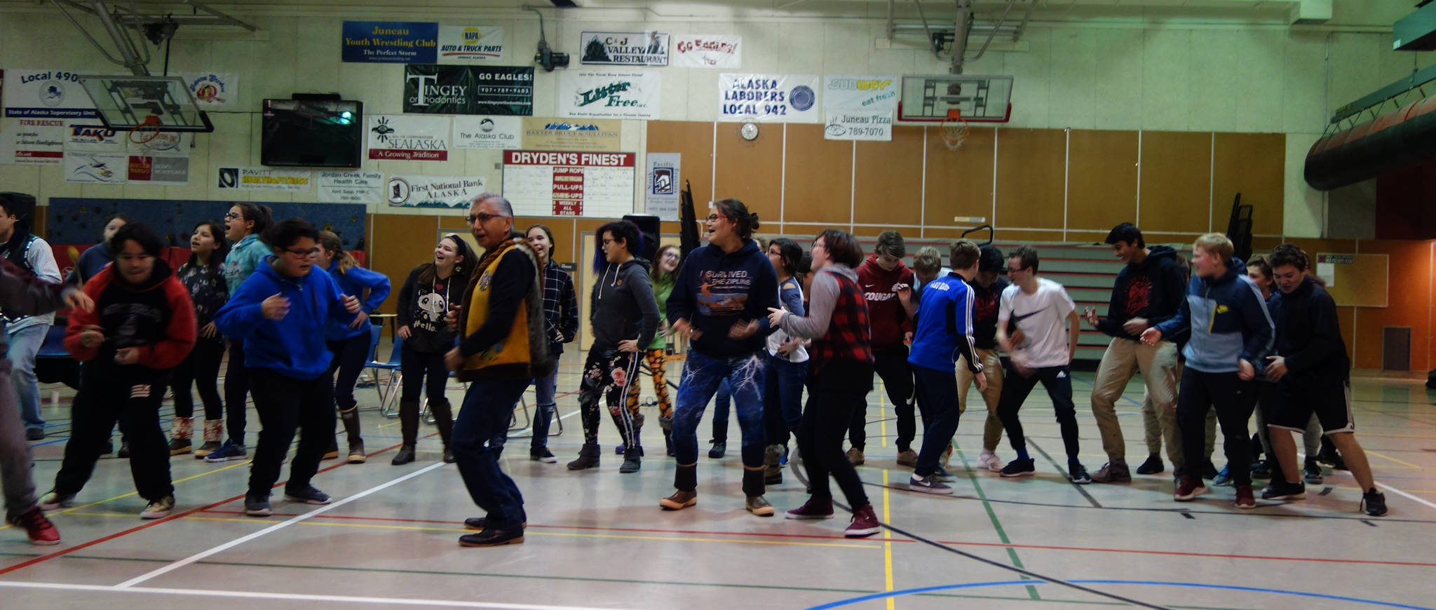 Floyd Dryden Middle School students take to the gymnasium floor to dance along with students singing a Tlingit song about respecting elders and community members at the “Transfer of Core Cultural Values Panels Ceremony” at Floyd Dryden Middle School on Wednesday, Nov. 22. (Clara Miller | Capital City Weekly)