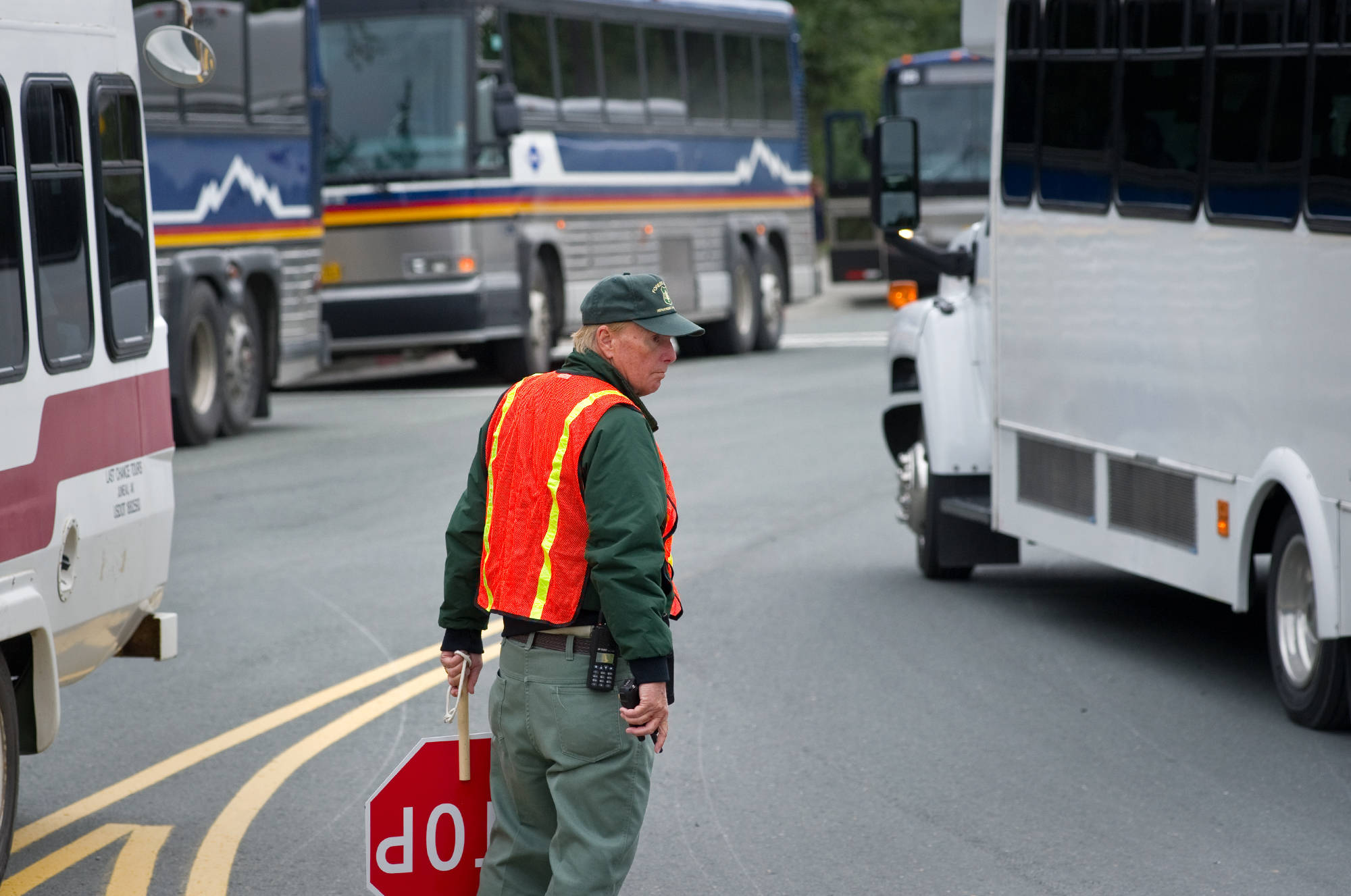 In this August 2013 file photo, Jack Hempstead of the U.S. Forest Service directs bus traffic at the Mendenhall Glacier Visitor Center. (Michael Penn | Juneau Empire file)