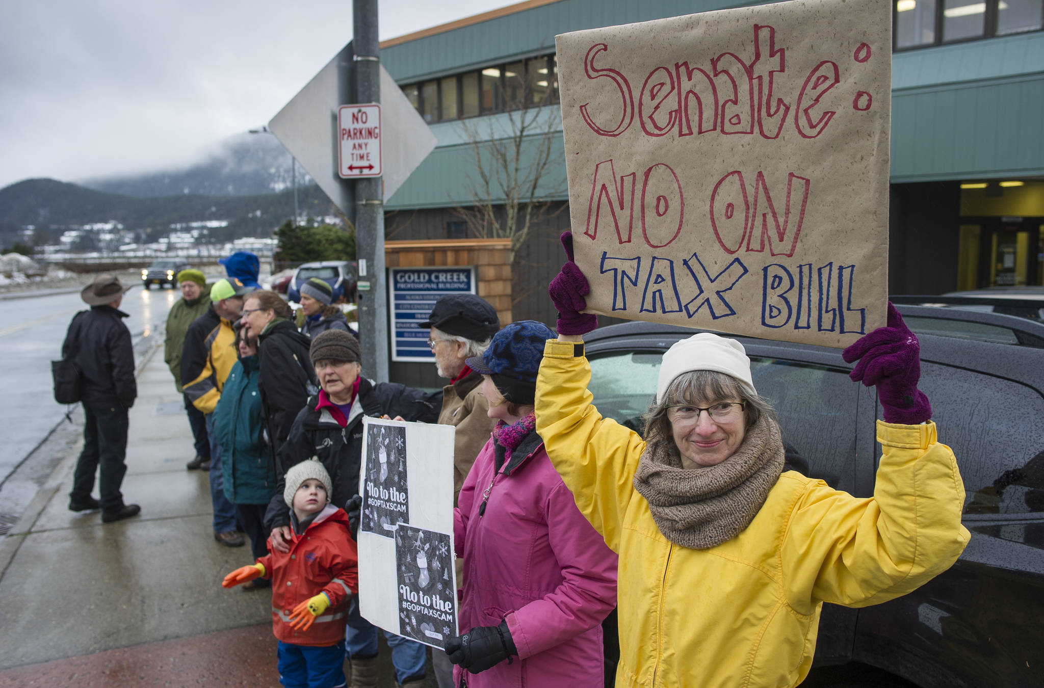 Luann McVey, right, joins about a dozen people to protest the U.S. Senate’s proposed tax reform bill in front of Juneau’s Congressional Delegation Office on Glacier Avenue on Wednesday, Nov. 29, 2017. (Michael Penn | Juneau Empire)