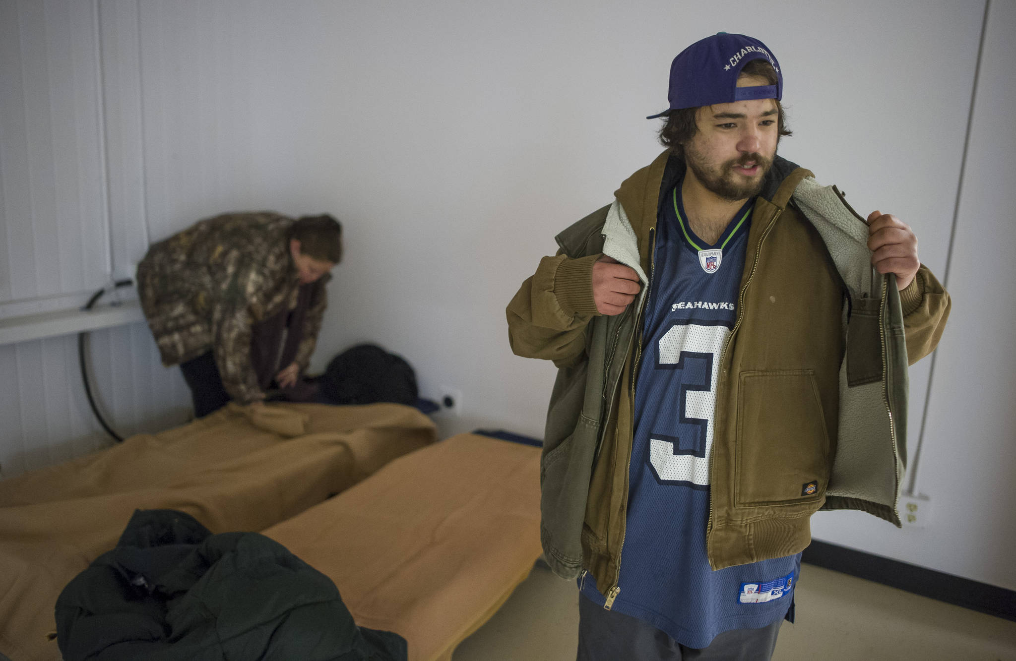 Chris King, 26, and his girlfriend, Chellsy Melton, 32, set up their cots at a new warming shelter in the old Public Safety Building on Whittier Street on Friday, Dec. 1, 2017. (Michael Penn | Juneau Empire)