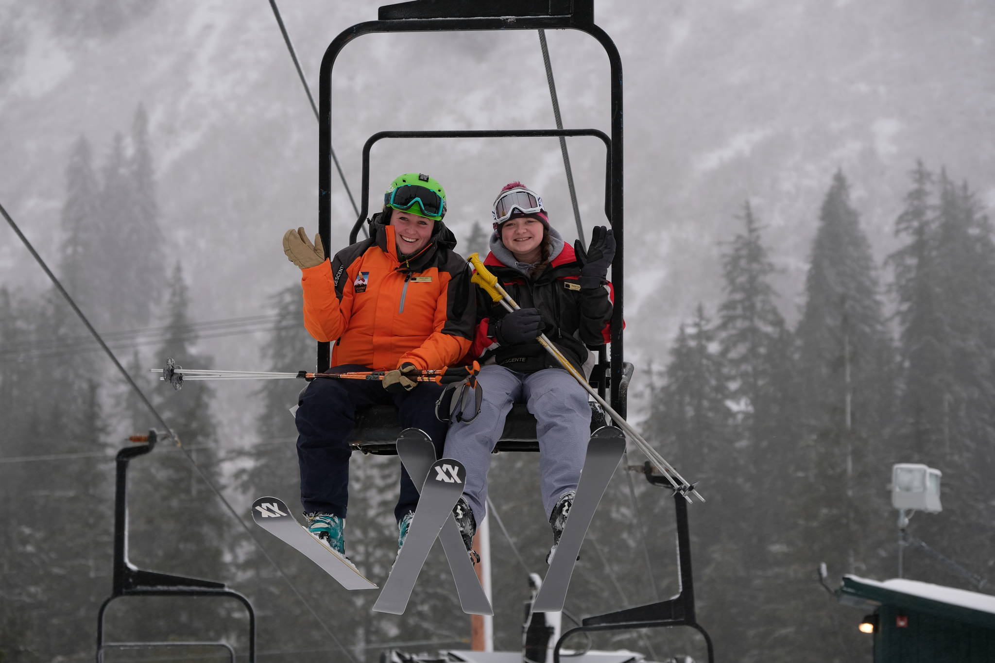 Eaglecrest ski instructor Sarah Milks rides up an Eaglecrest chairlift with a fellow instructor, Saturday, Dec. 2, 2017. (Lance Nesbitt | For the Juneau Empire)