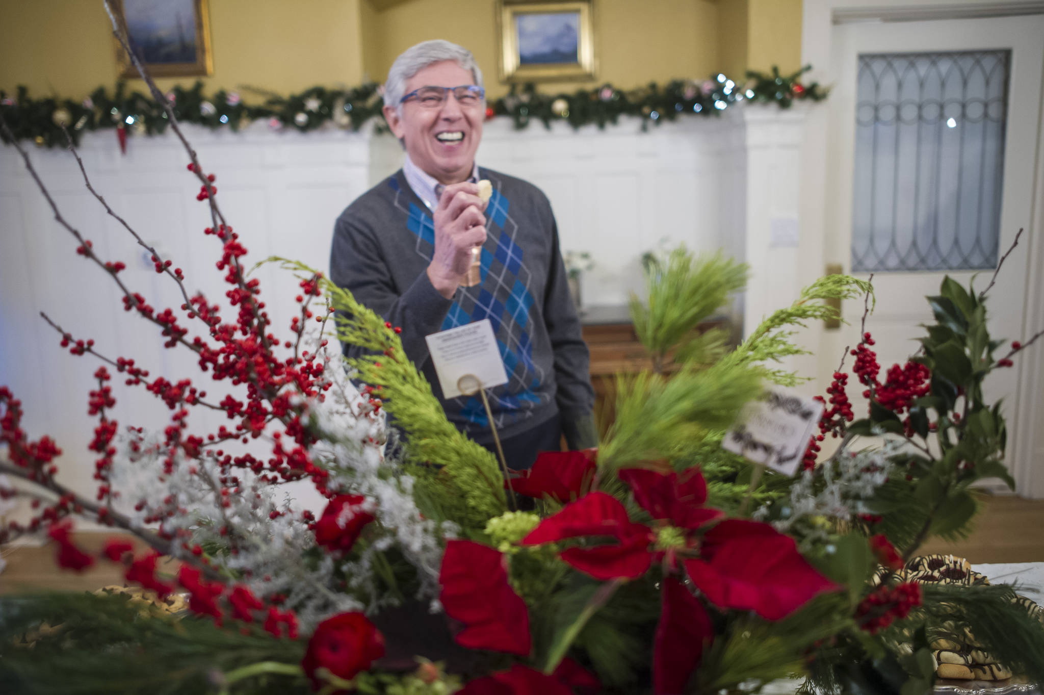 Lt. Gov. Byron Mallott laughs while sampling a cookie before the Governor’s Open House on Tuesday, Dec. 5, 2017. (Michael Penn | Juneau Empire)