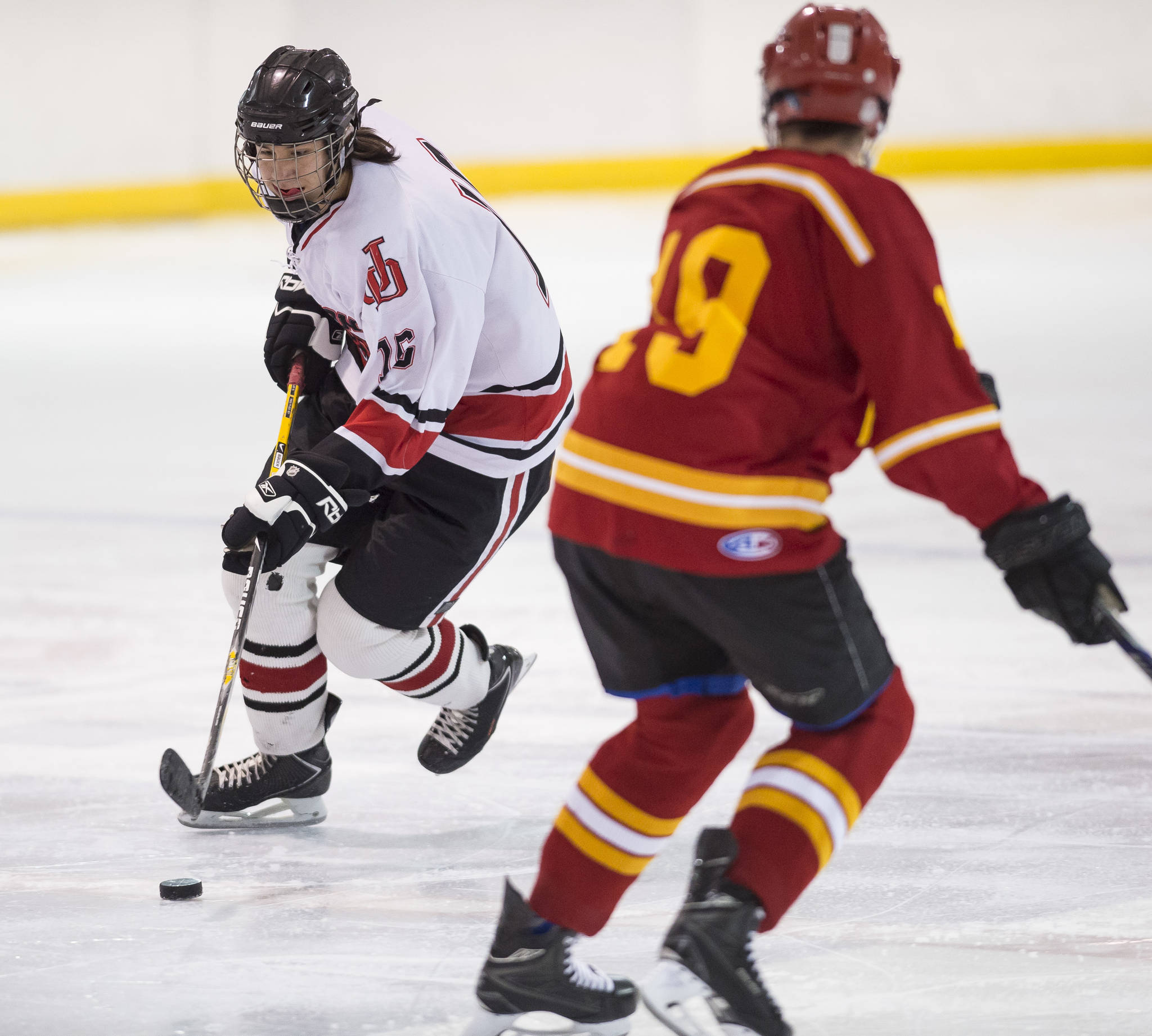 Juneau-Douglas&rsquo; Erik Genitz, left, moves the puck against a West Valley player at Treadwell Arena on Thursday, Nov. 30, 2017. (Michael Penn | Juneau Empire)