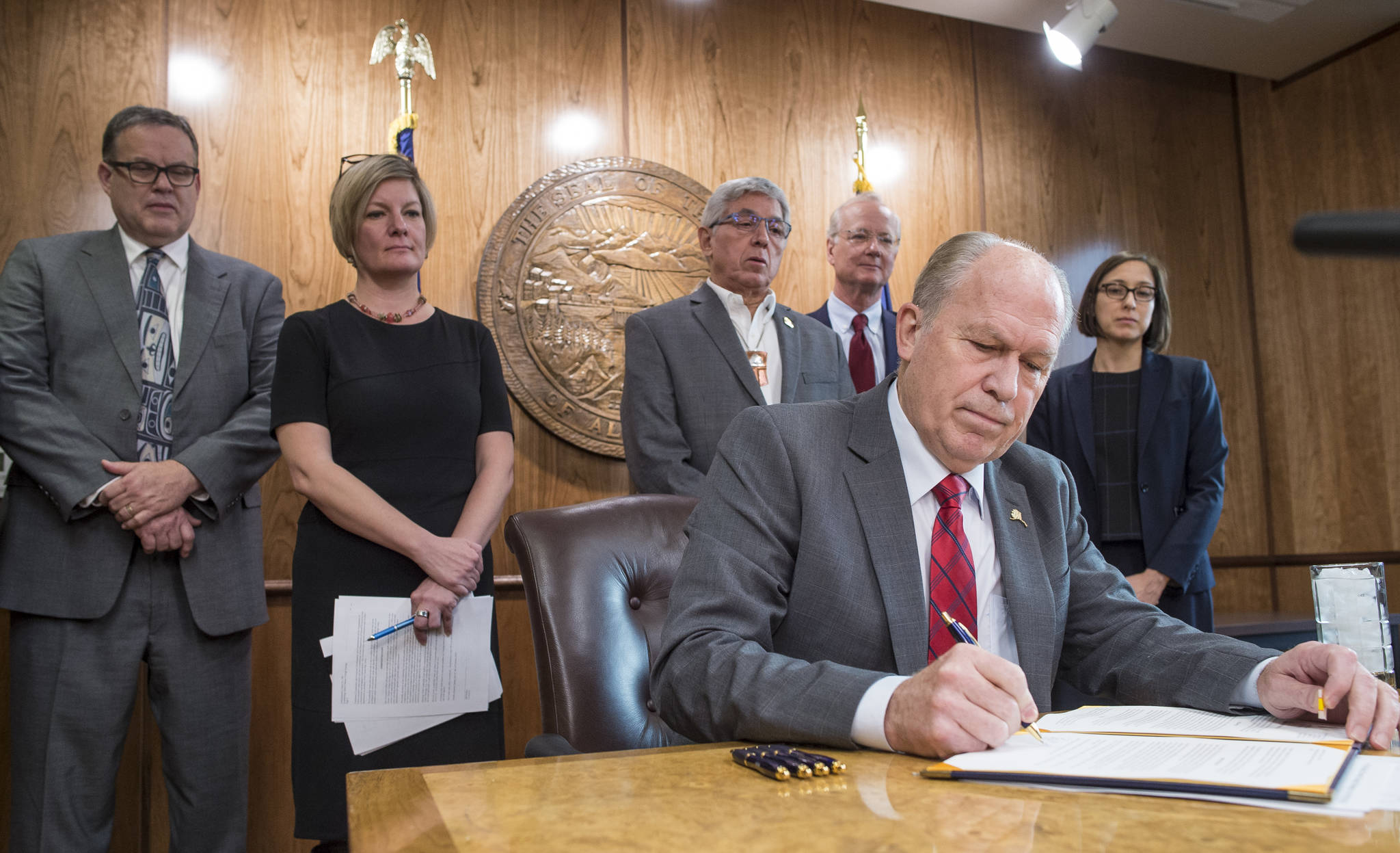 Gov. Bill Walker signs an Executive Order in his Capitol conference room on Tuesday, Oct. 31, 2017, outlining his administration’s policy on climate change and creating the Climate Action for Alaska Leadership Team. Standing behind Gov. Walker are Department of Commerce, Community & Economic Development Deputy Commissioner Fred Parady, left, Attorney General Jahna Lindemuth, Lt. Gov. Byron Mallott, Department of Environmental Conservation Commissioner Larry Hartig and Senior Advisor on Climate Change Dr. Nikoosh Carlo. (Michael Penn | Juneau Empire File)