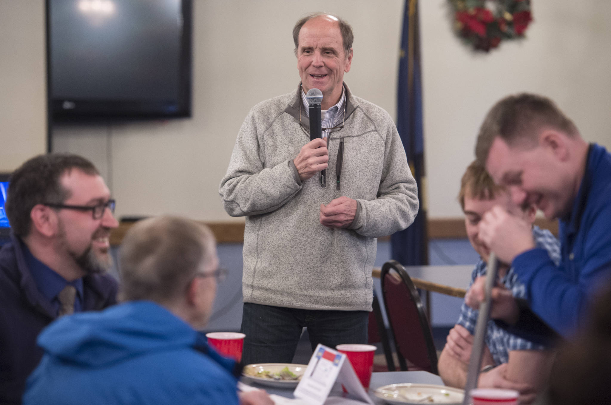 Bruce Denton watches members of the Juneau Chamber of Commerce experiment with magnets for his talk about the middle school physics program ”See the Change” at the Moose Lodge on Thursday, Dec. 14, 2017. (Michael Penn | Juneau Empire)