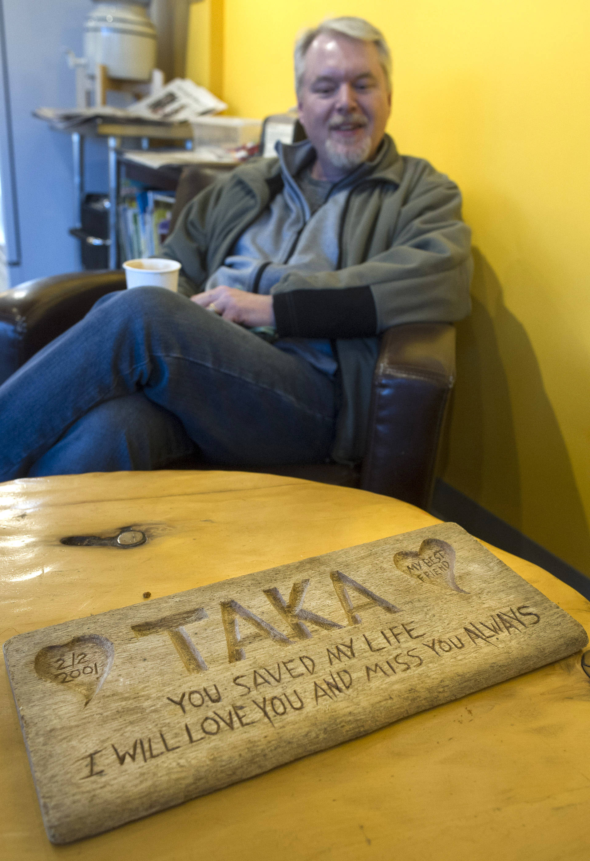 Guy Holt found a carved plaque on Sandy Beach 11 years ago and his been trying to find it owner ever since. Holt was photographed at Coppa on Thursday, Dec. 14, 2017. (Michael Penn | Juneau Empire)