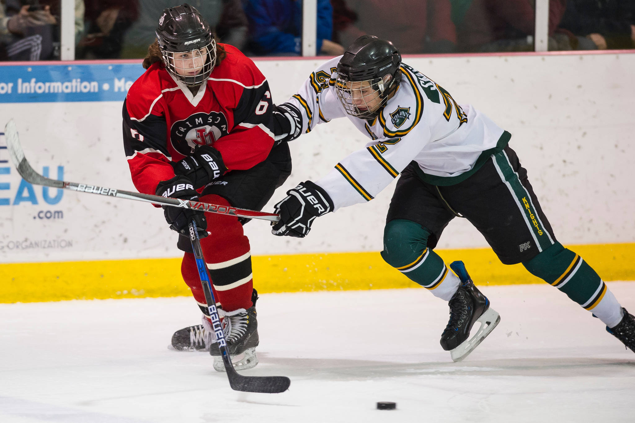 Juneau-Douglas’ Cameron Smith, left, passes against Colony’s Cooper Smith at Treadwell Arena on Friday, Dec. 15, 2017. Colony won 6-1. (Michael Penn | Juneau Empire)