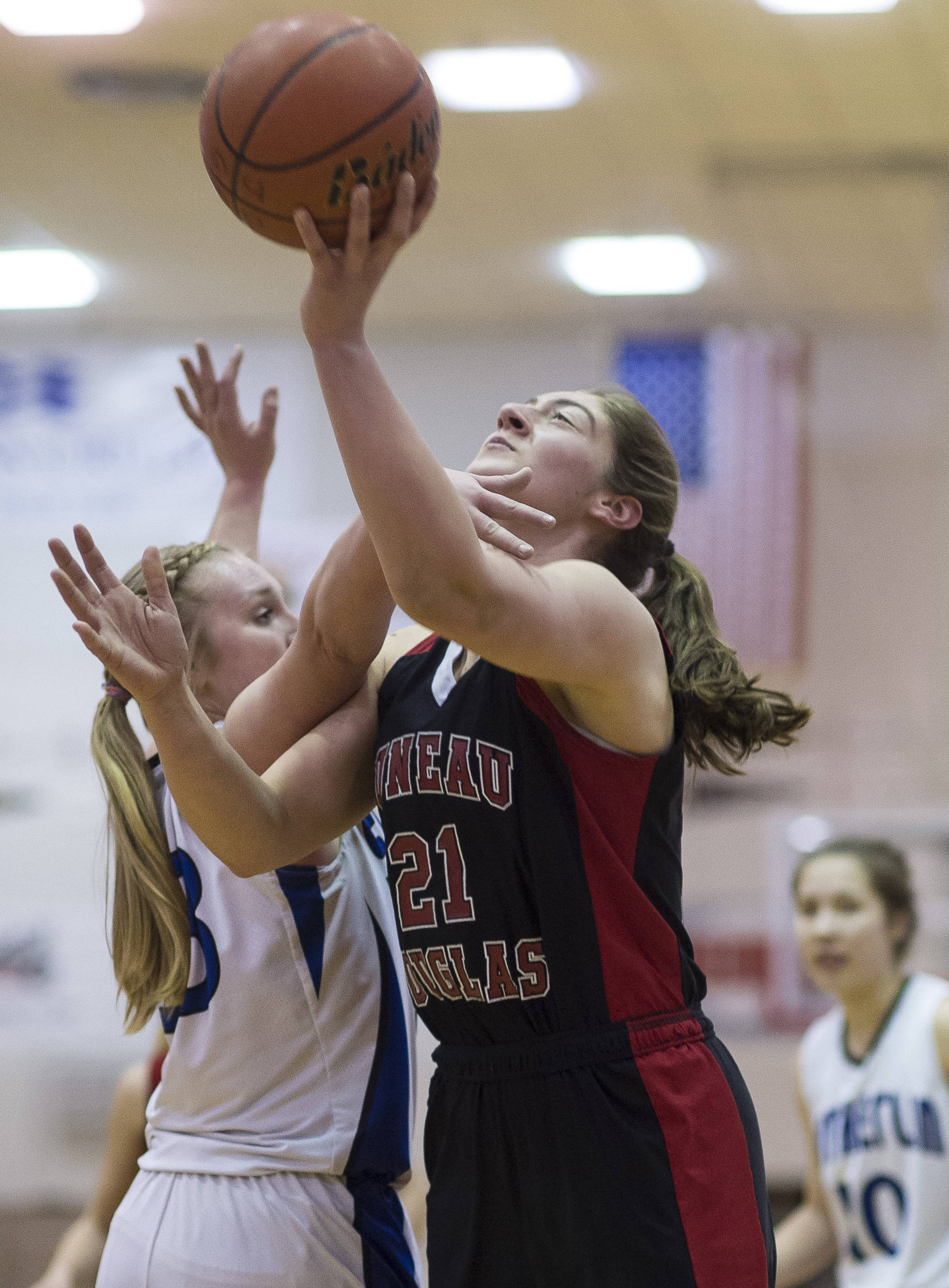 Juneau-Douglas’ Cassie Dzinich, right, is fouled by Sutherlin’s Taylor Moser during their Capital City Classic Basketball Tournament game at JDHS on Thursday, Dec. 28, 2017. (Michael Penn | Juneau Empire)